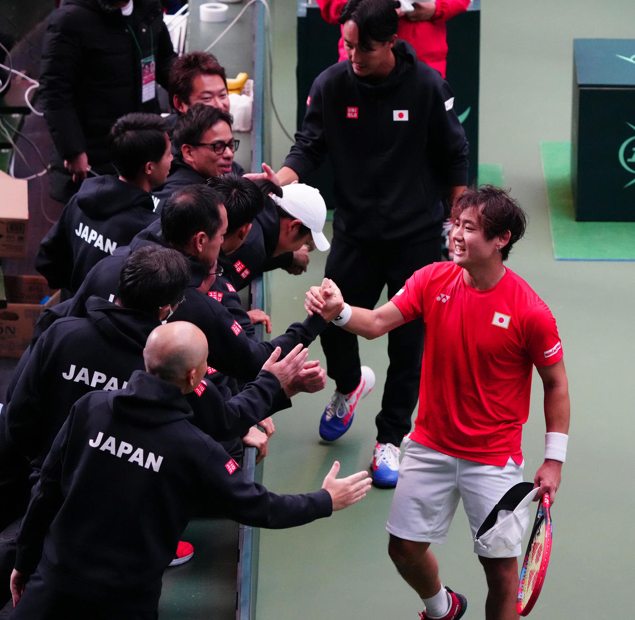 デビスカップ国別対抗戦　日本対ポーランド　西岡良仁対ダニエル・ミハルスキ　勝利しチームスタッフと握手を交わす西岡（右手前）（撮影・清水貴仁）