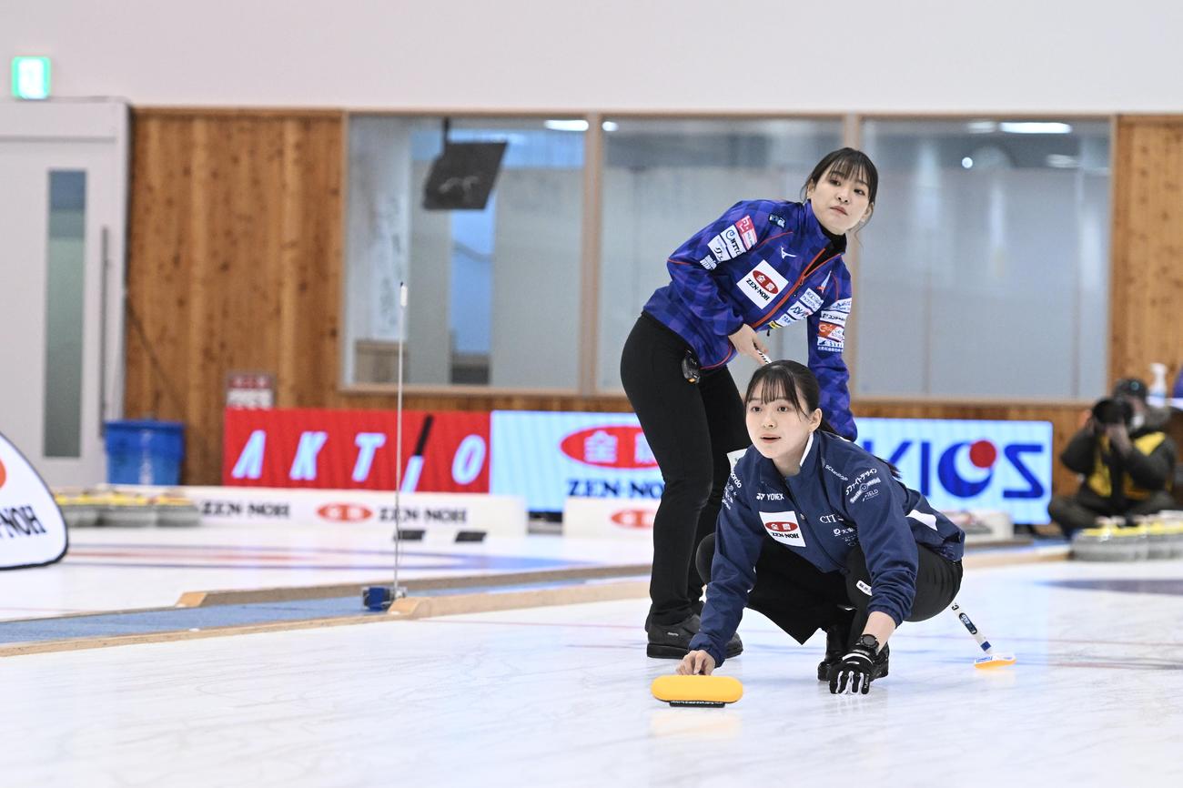 ストーンを投じるSC軽井沢クラブ上野美優。奥はロコ・ソラーレ吉田知那美（C）JCA IDE