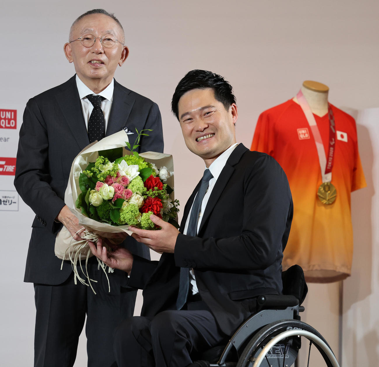 引退会見でユニクロ柳井会長兼社長（左）から花束を受け取る国枝（撮影・野上伸悟）