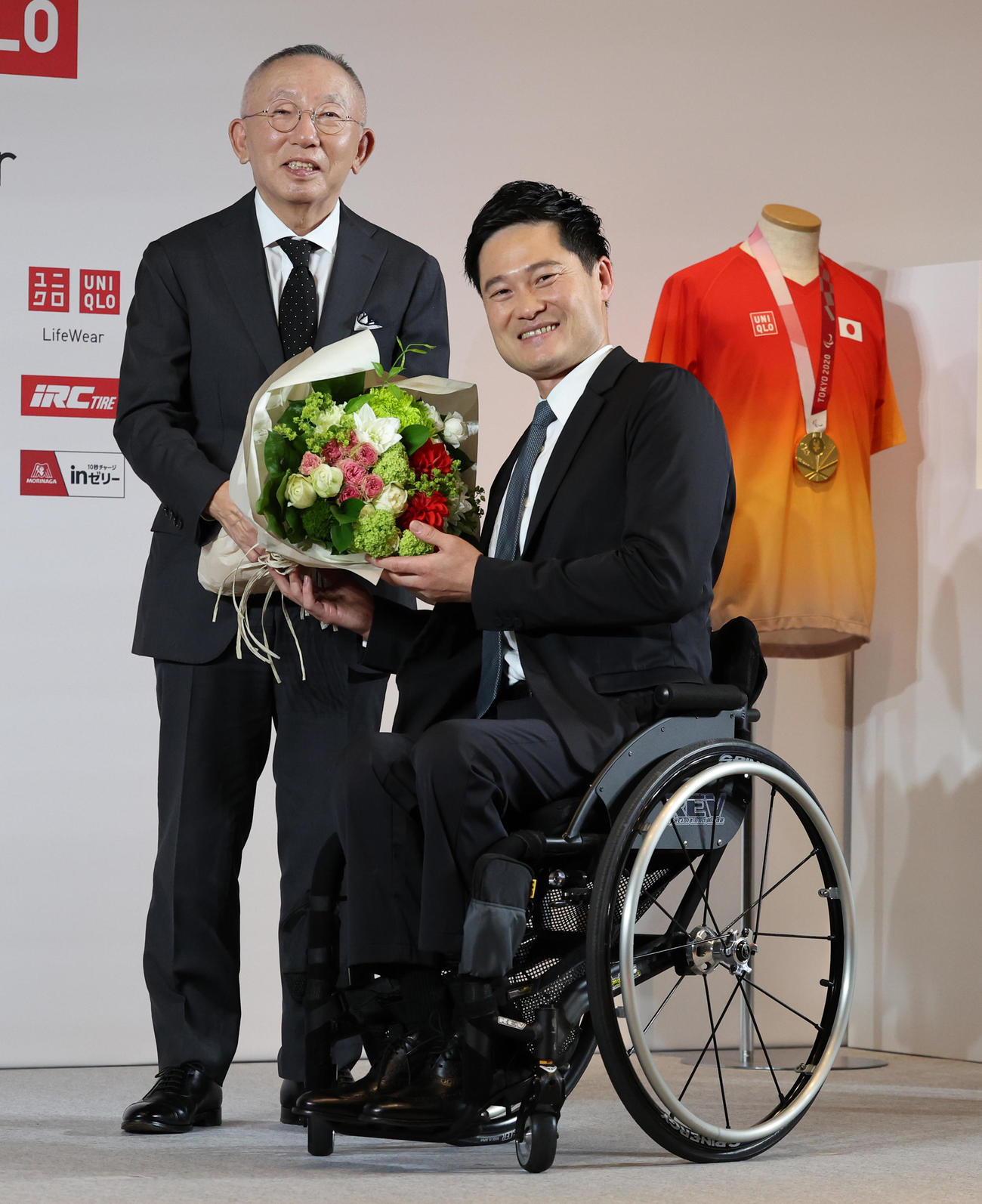 引退会見でユニクロ柳井会長兼社長（左）から花束を受け取る国枝（撮影・野上伸悟）