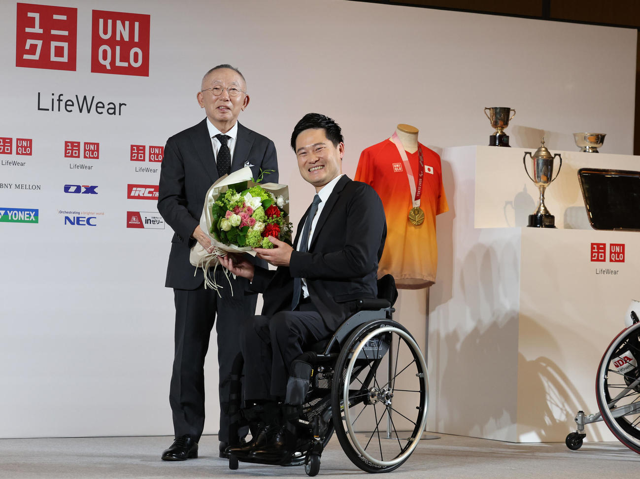引退会見でユニクロ柳井会長兼社長（左）から花束を受け取る国枝（撮影・野上伸悟）
