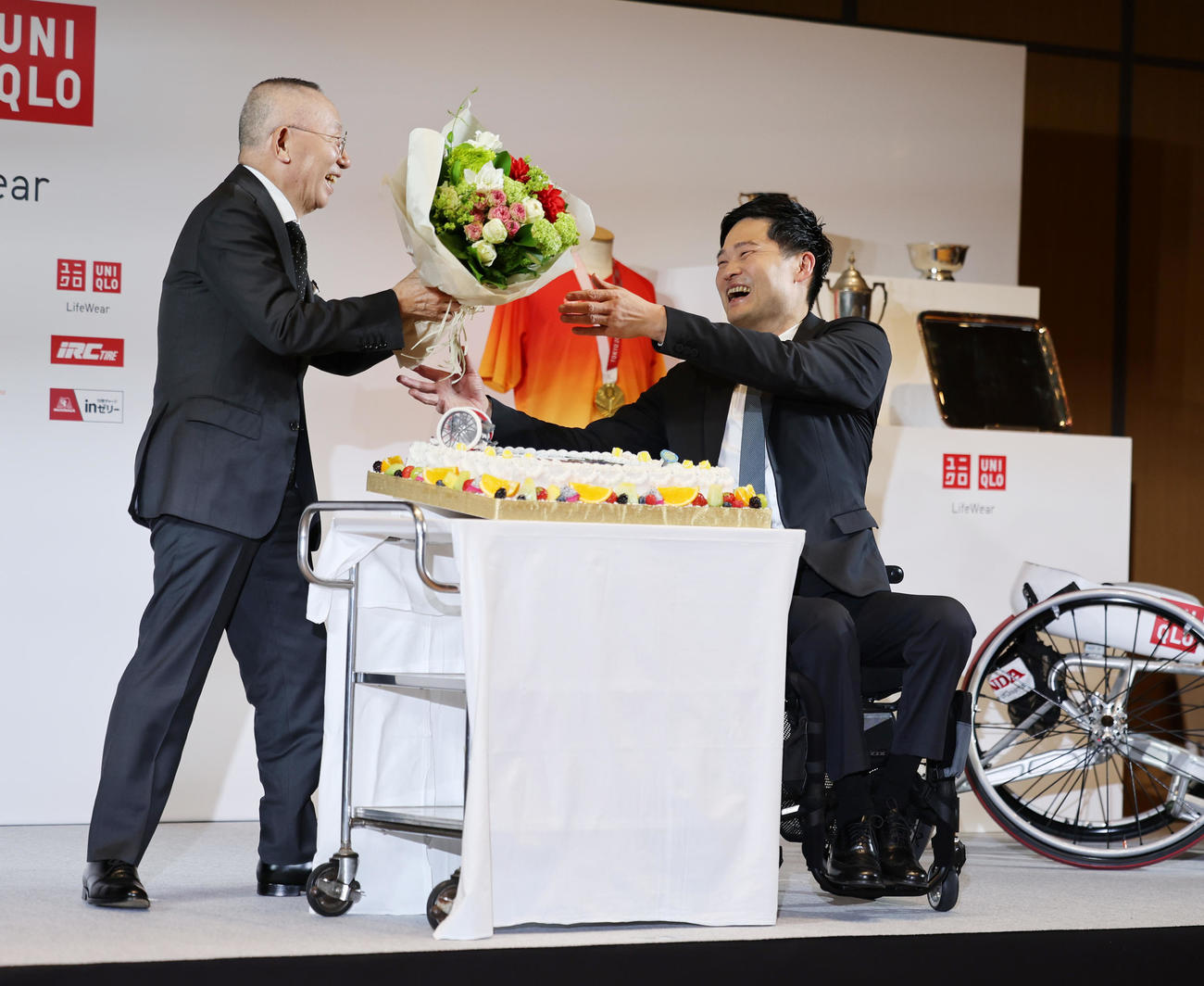 引退会見でユニクロ柳井会長兼社長（左）から花束を受け取る国枝。サプライズのお祝いケーキも贈られた（撮影・野上伸悟）