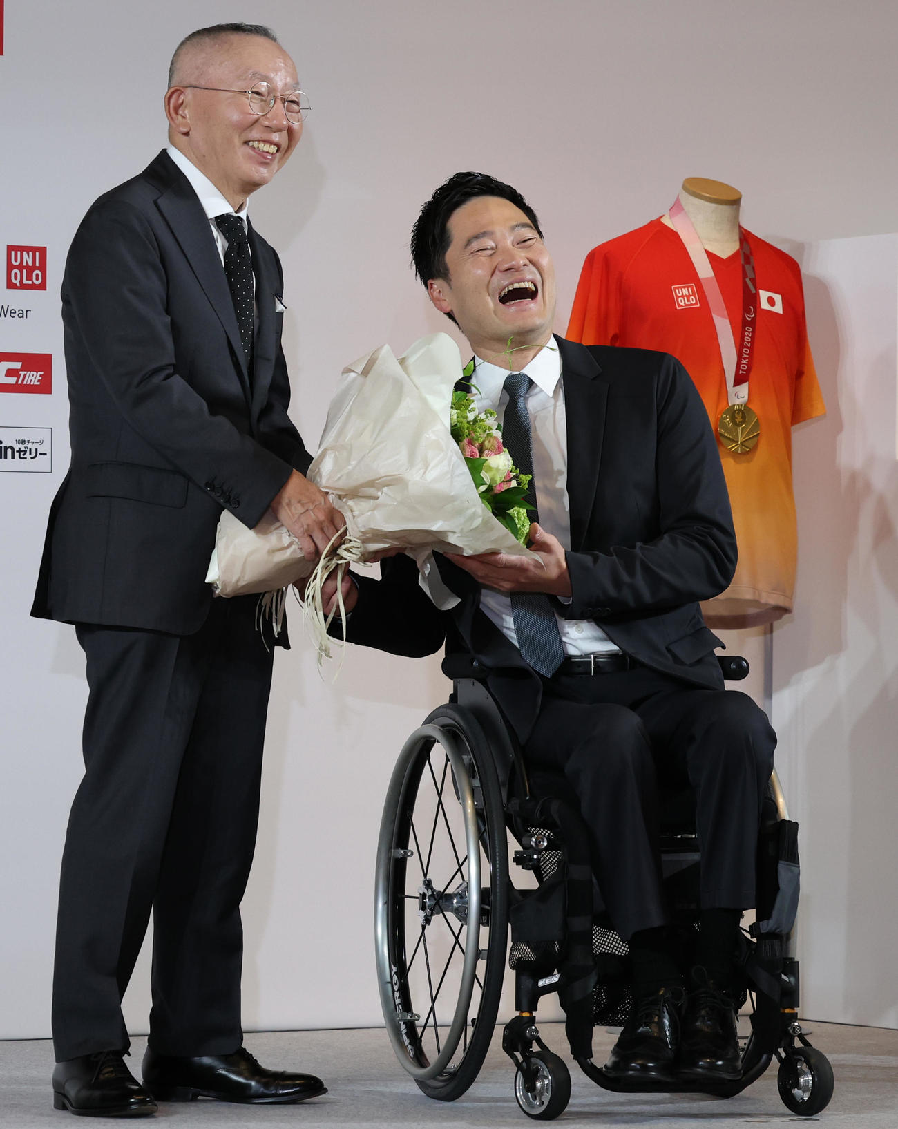引退会見でユニクロ柳井会長兼社長（左）から花束を受け取る国枝（撮影・野上伸悟）