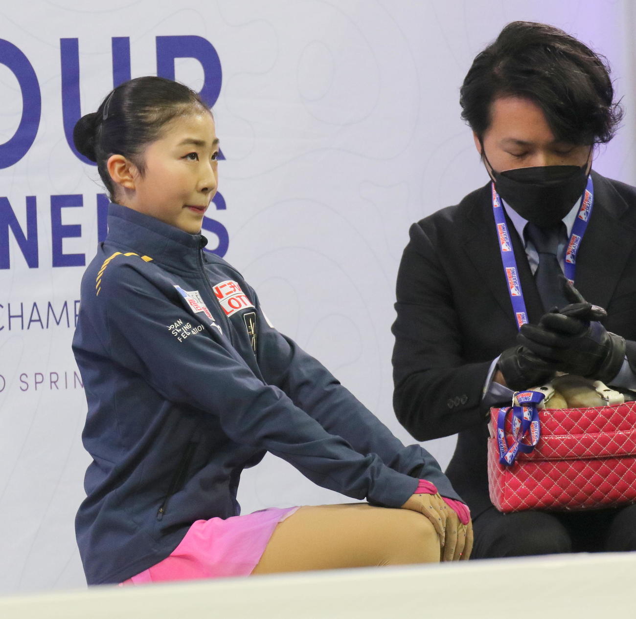 フィギュアスケート4大陸選手権　女子フリーのスコアが出る前、緊張した表情で背筋を伸ばす千葉百音。右は田中総司コーチ（撮影・木下淳）