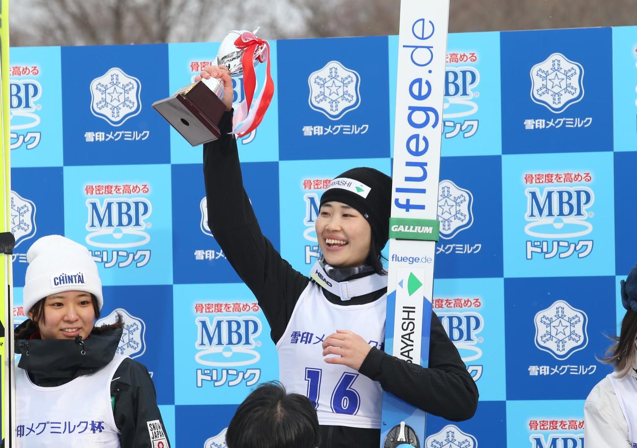女子で優勝した岩佐（中央）は、表彰台でトロフィーを掲げて笑顔。左は2位の一戸くる実（撮影・中島洋尚）　