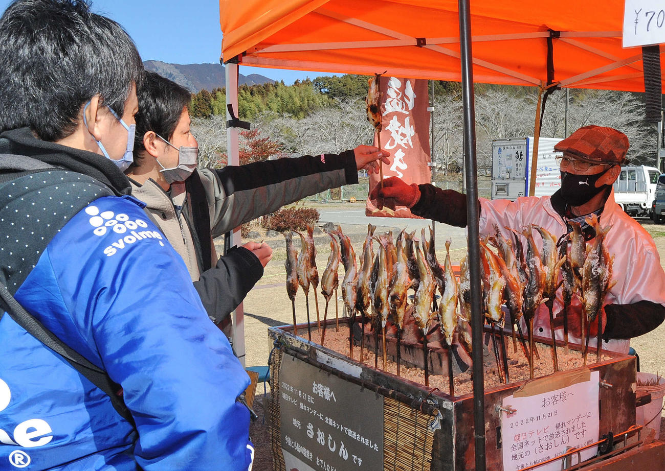アユの塩焼きを購入する来場者ら（左）