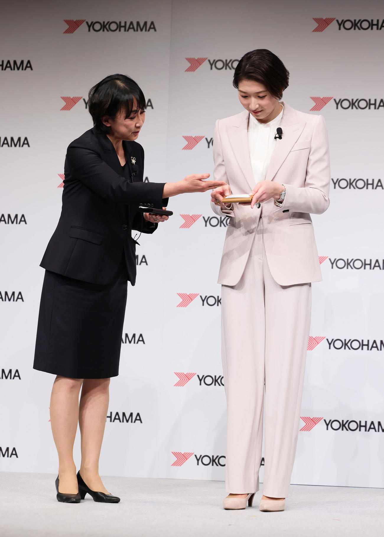 「横浜ゴム所属発表会」に登壇し、講師から名刺交換の指導を受ける池江璃花子（右）（撮影・足立雅史）