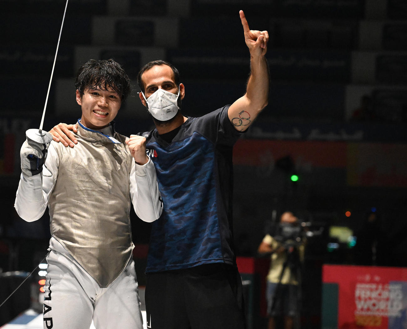 フェンシング世界ジュニア選手権の男子フルーレ個人で金メダルに輝いた飯村一輝（左）とエルワン・ルペシュー・コーチ（日本協会提供）