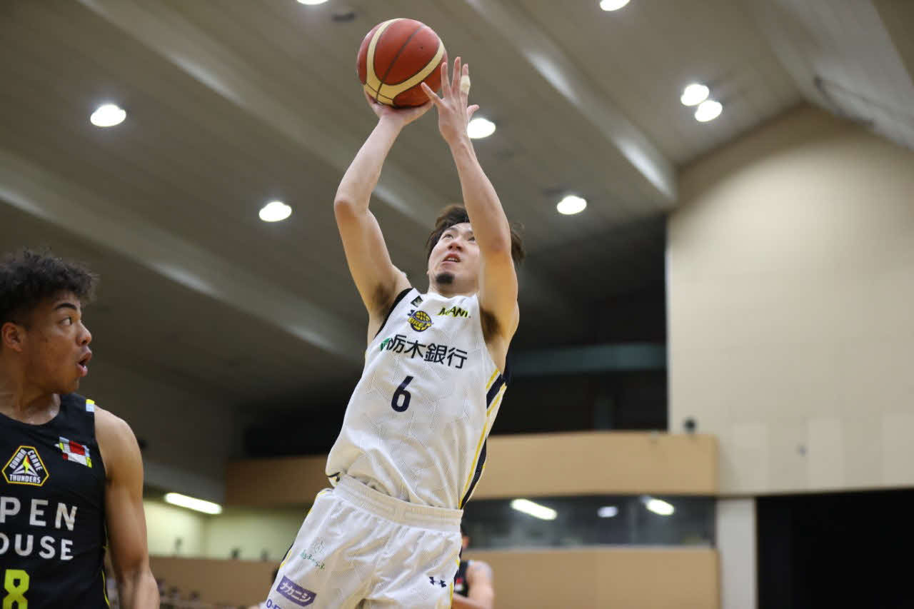 難しい体勢からシュートを打つ宇都宮比江島とそれに驚く群馬八村（コピーライトBLEAGUE）