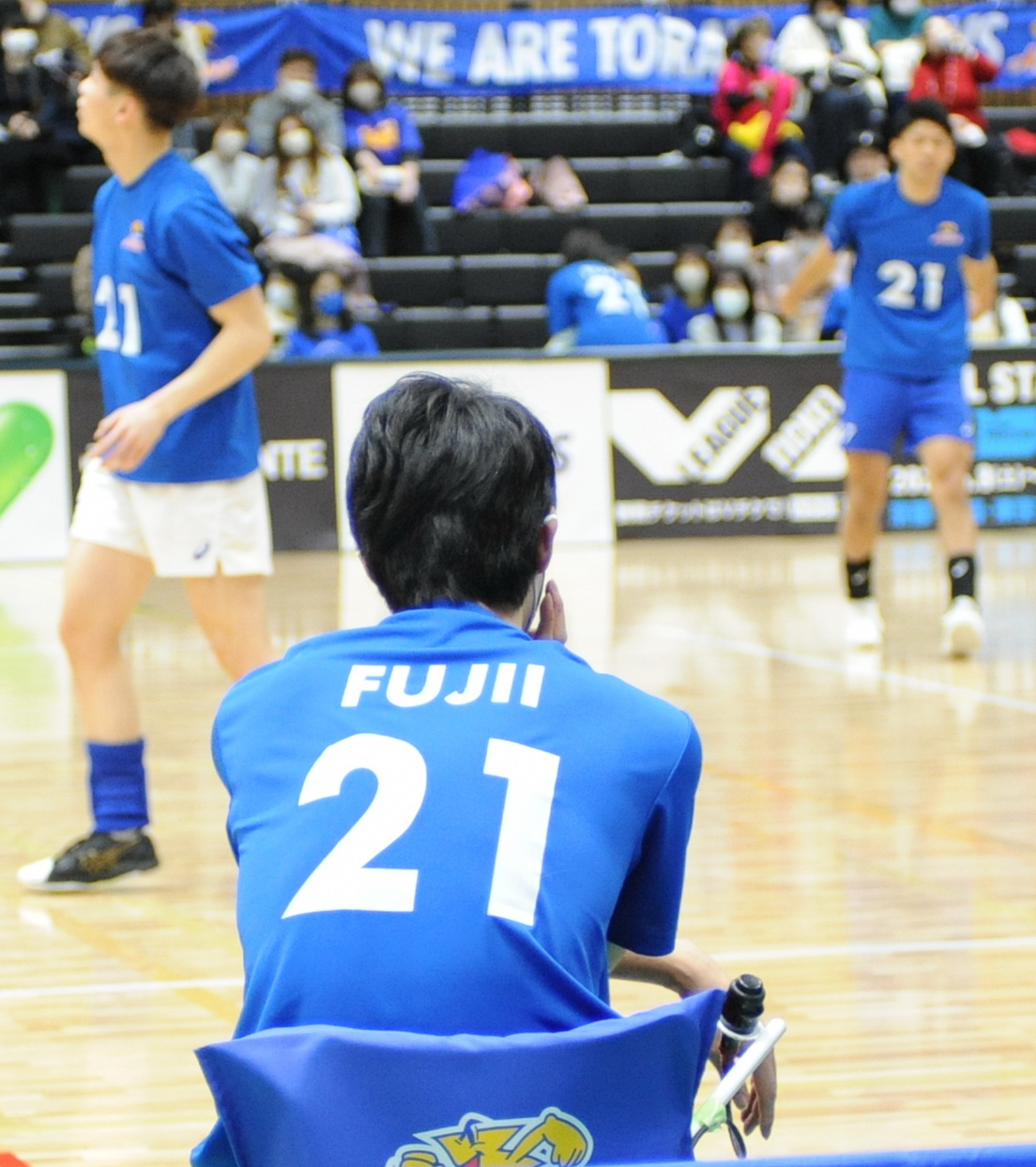 背番号21のユニホームを着て練習を見守る篠田監督（手前）　　