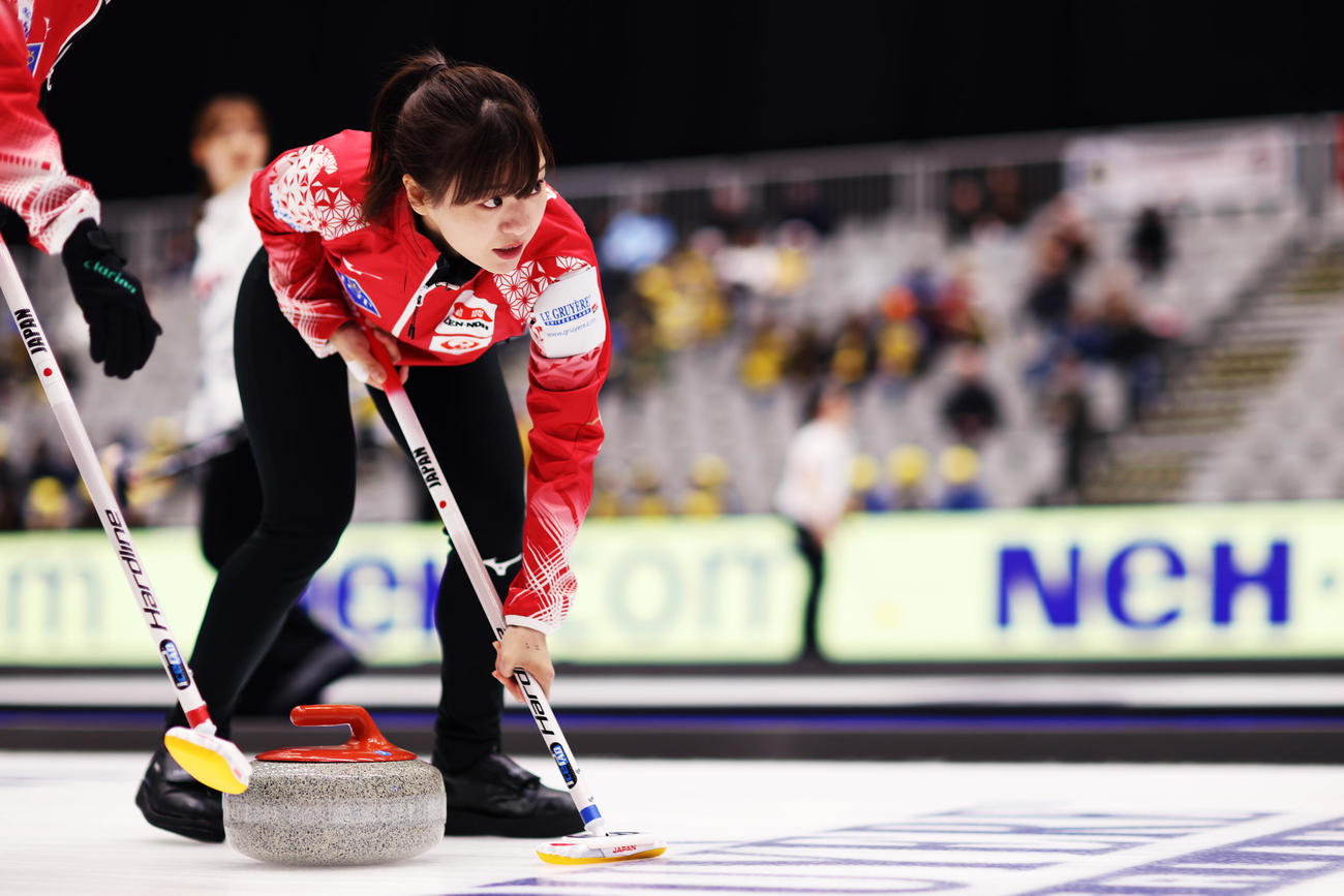1次リーグドイツ戦で真剣な表情でスイープする日本代表ロコ・ソラーレの吉田知（C）WCF／Stephen Fisher