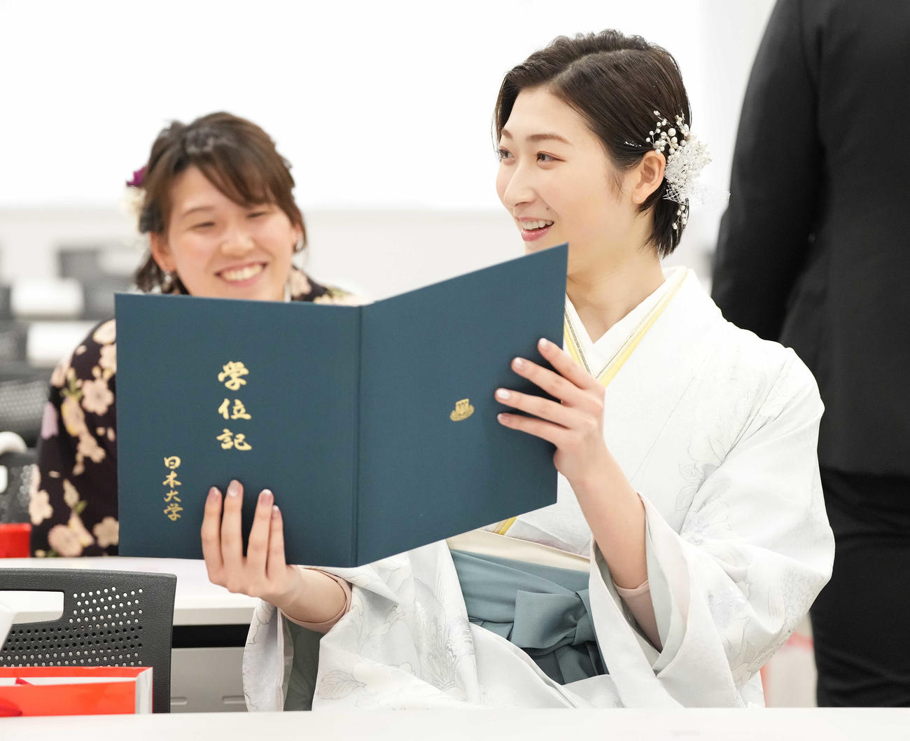 学位記を手に笑顔の池江。奥は小堀（撮影・鈴木みどり）