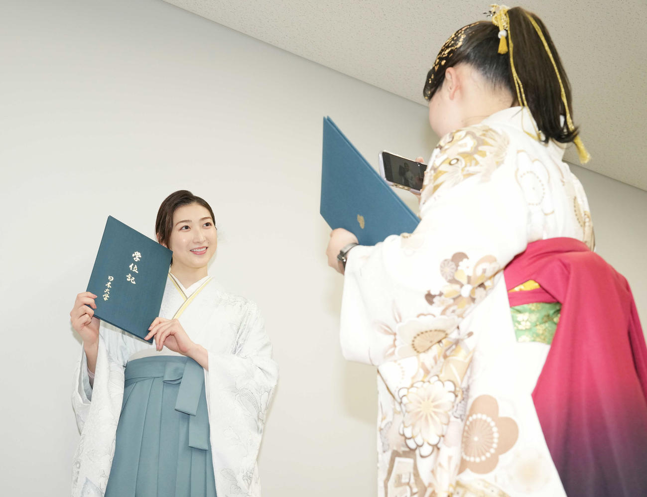 学位記を手に写真を撮ってもらう池江（撮影・鈴木みどり）