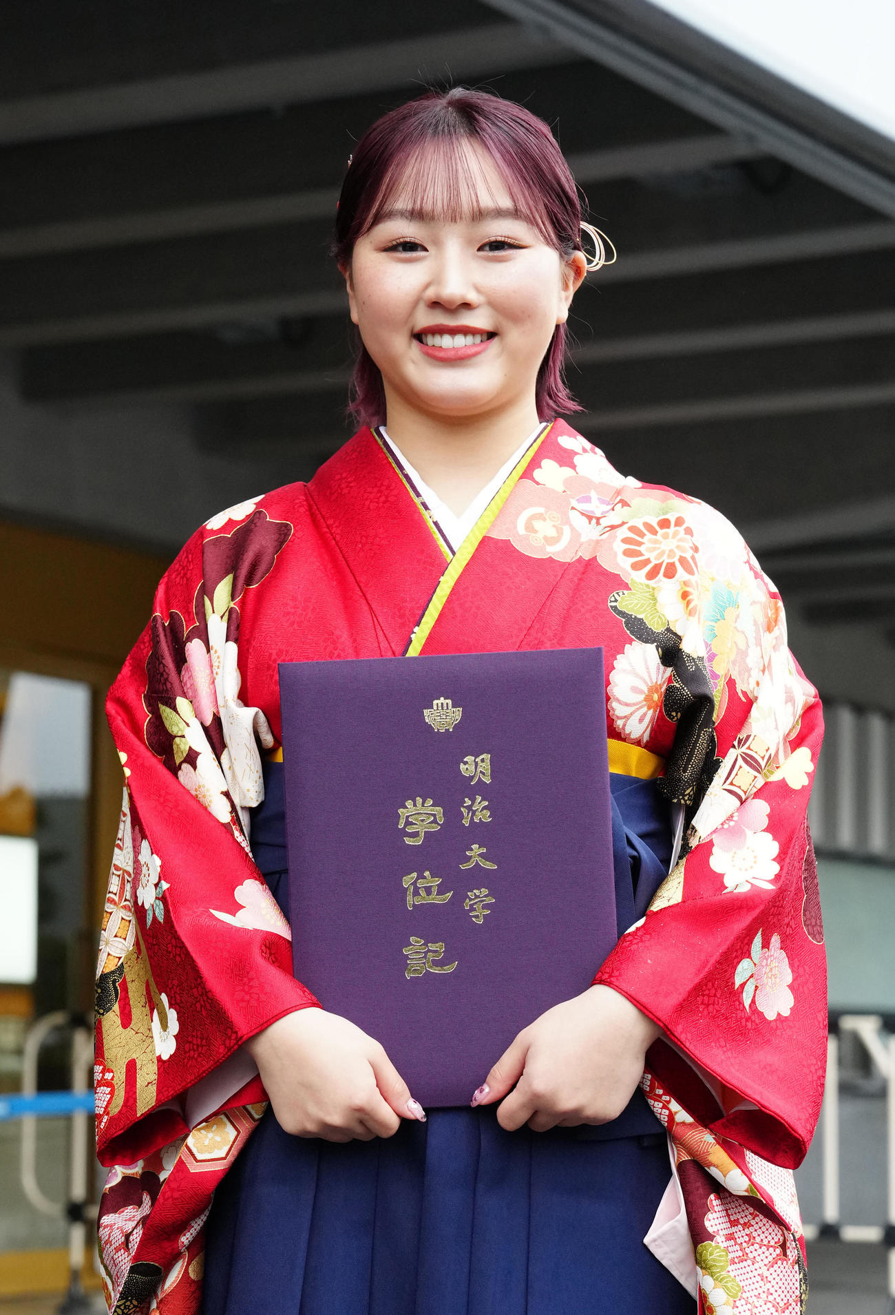 明大卒業式に臨み、写真に納まるフィギュアスケートの樋口新葉（撮影・江口和貴）