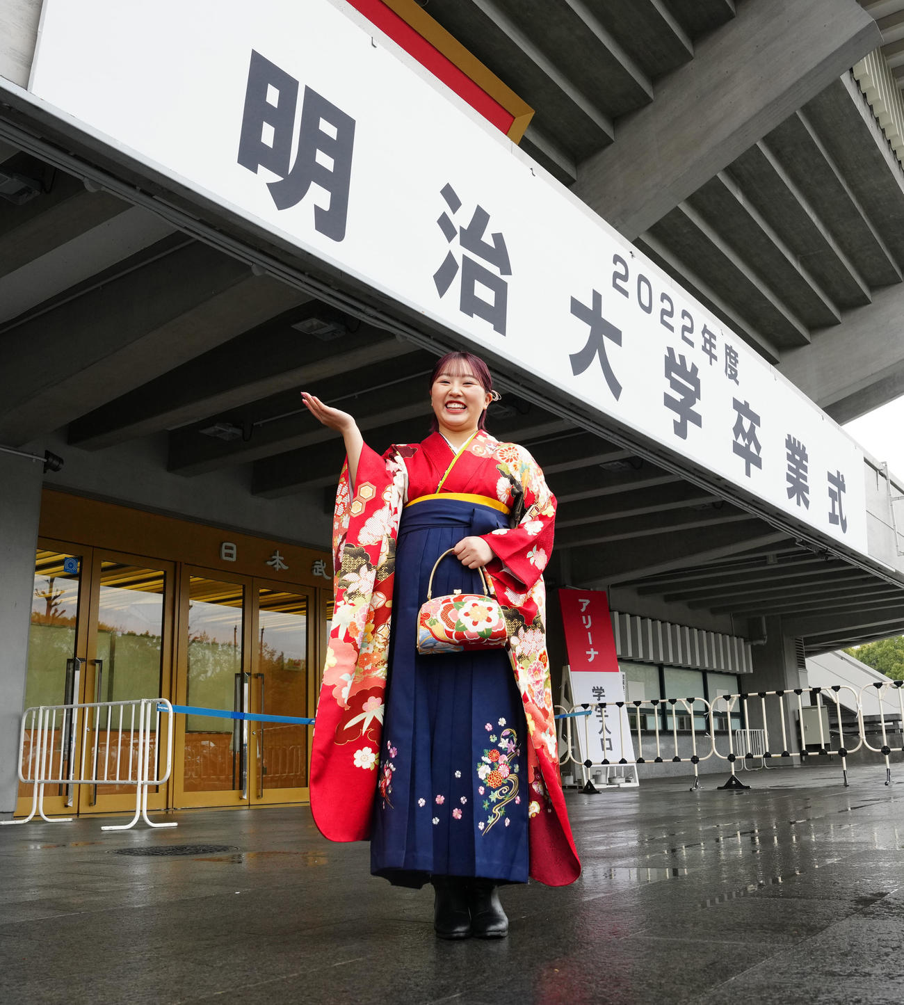 明大卒業式に臨み、看板の前で写真に納まるフィギュアスケートの樋口（撮影・江口和貴）
