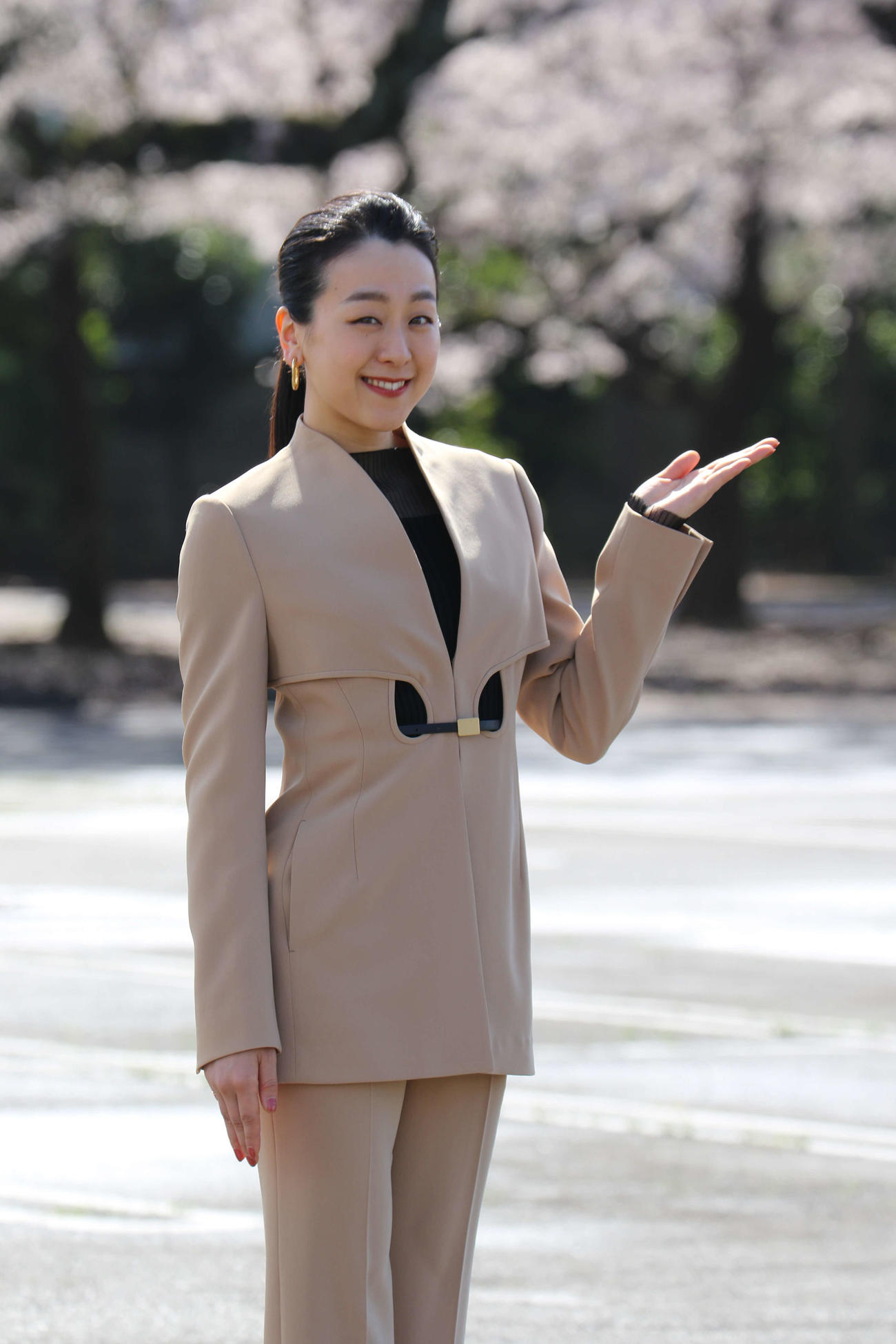 桜が満開の建設予定地で笑顔の浅田さん