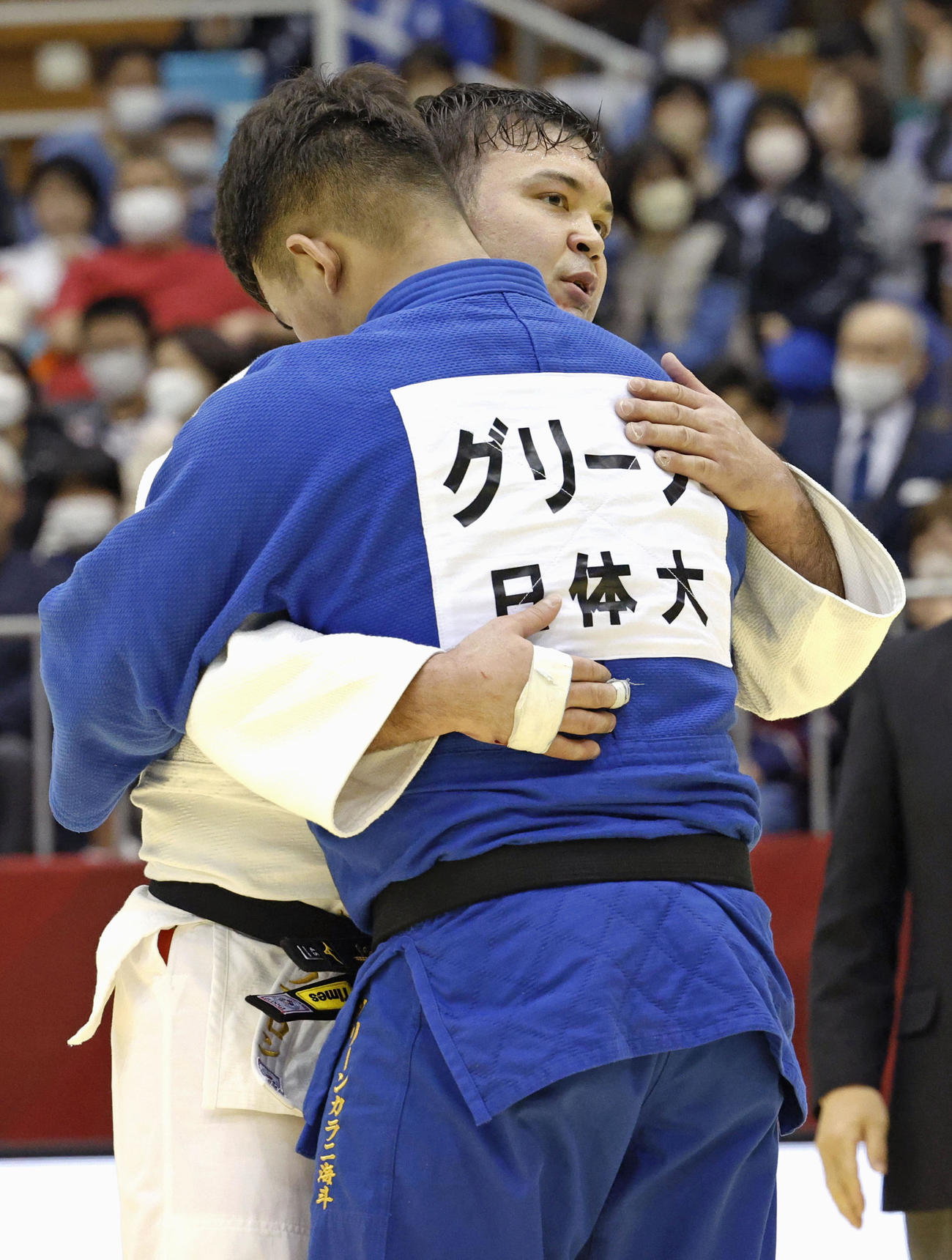 男子100キロ級で優勝し、グリーン海斗（手前）と抱き合うウルフ・アロン（共同）