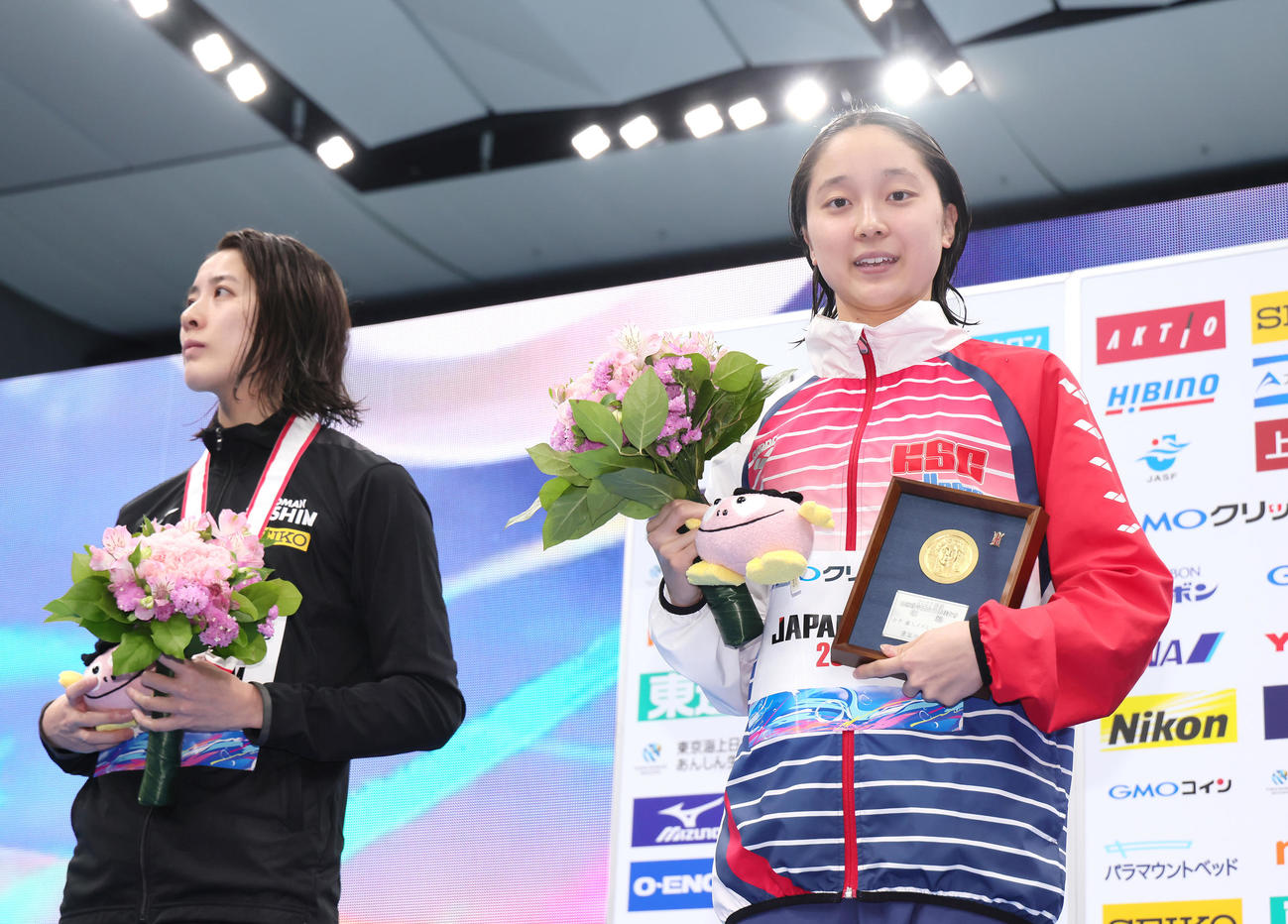 女子200メートル個人メドレー決勝で優勝し笑顔を見せる成田（右）の横で浮かない表情を見せる2位大橋（撮影・足立雅史）