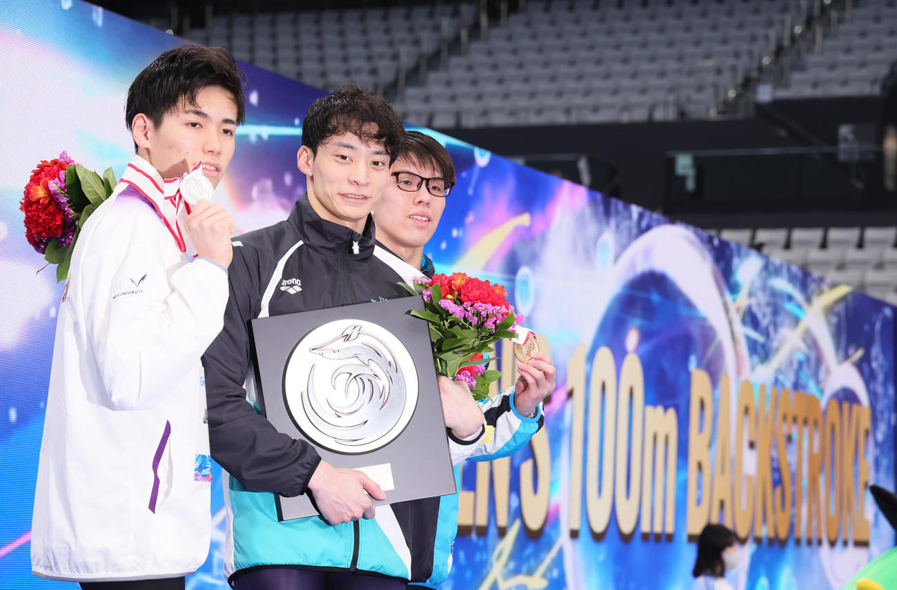 男子100メートル背泳ぎで10連覇を達成した入江（中央）。左は2位松山、右は3位三浦（撮影・足立雅史）