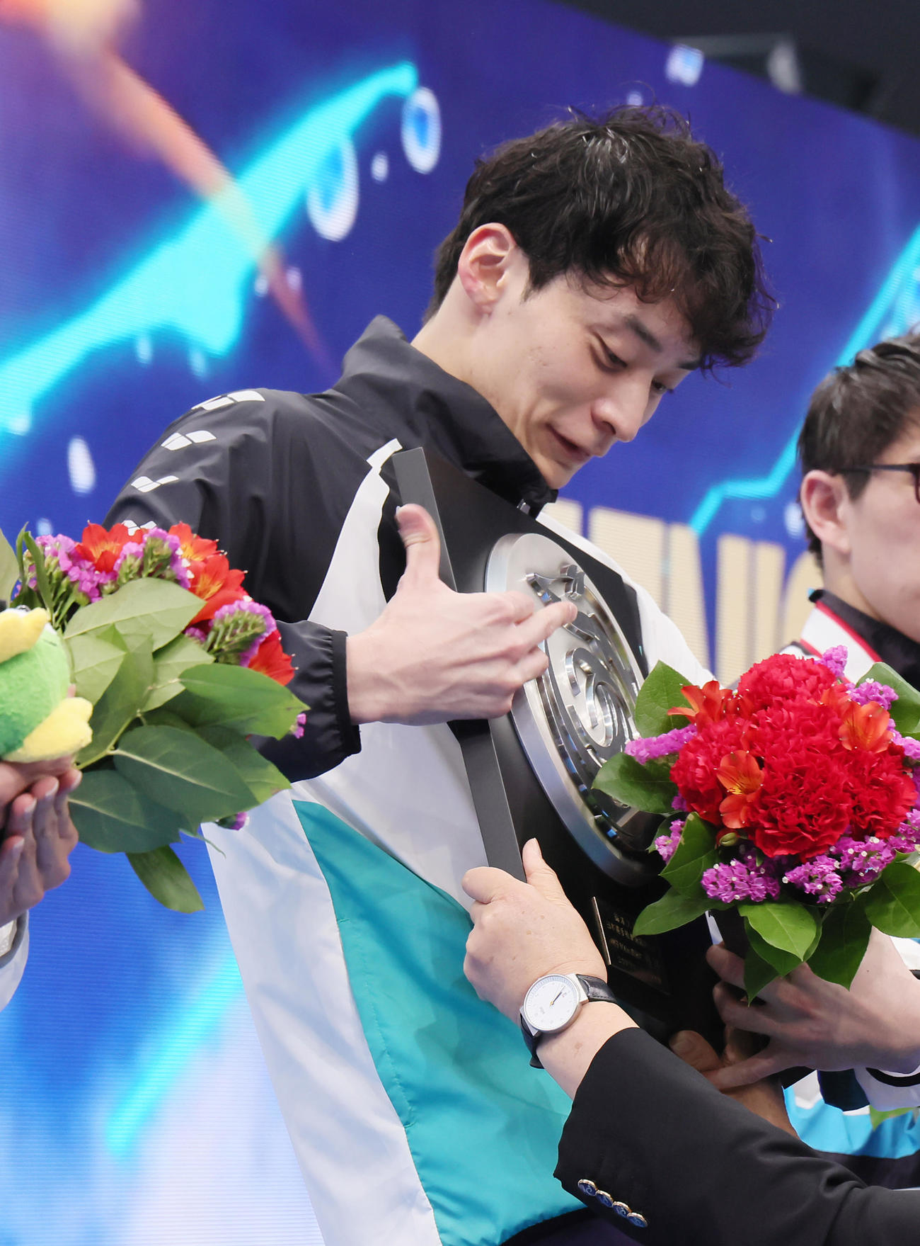 男子100メートル背泳ぎで10連覇を達成した入江は優勝盾を重たそうに抱える（撮影・足立雅史）