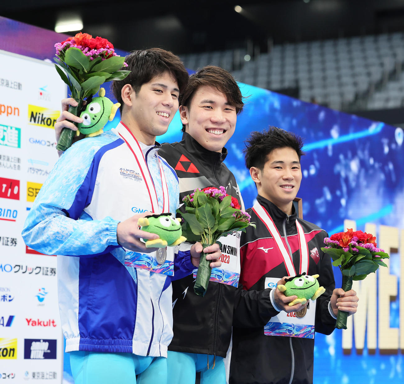 男子200メートル自由形決勝の表彰台で笑顔を見せる優勝の松元（中央）。左は2位真野、右は3位田中（撮影・足立雅史）