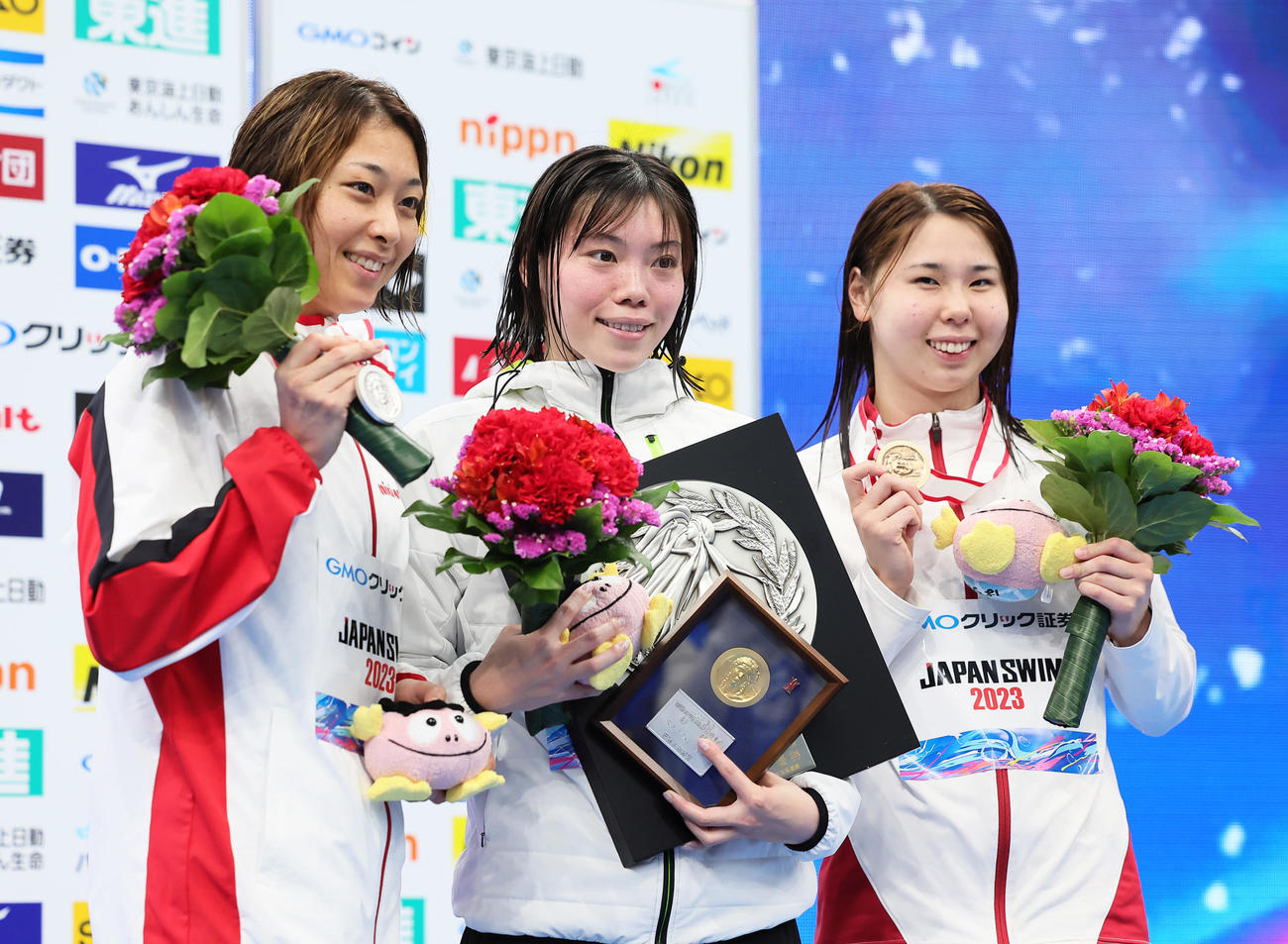 女子100メートル平泳ぎ決勝の表彰台で笑顔を見せる優勝の青木（中央）。左は2位鈴木、右は3位宮坂（撮影・足立雅史）