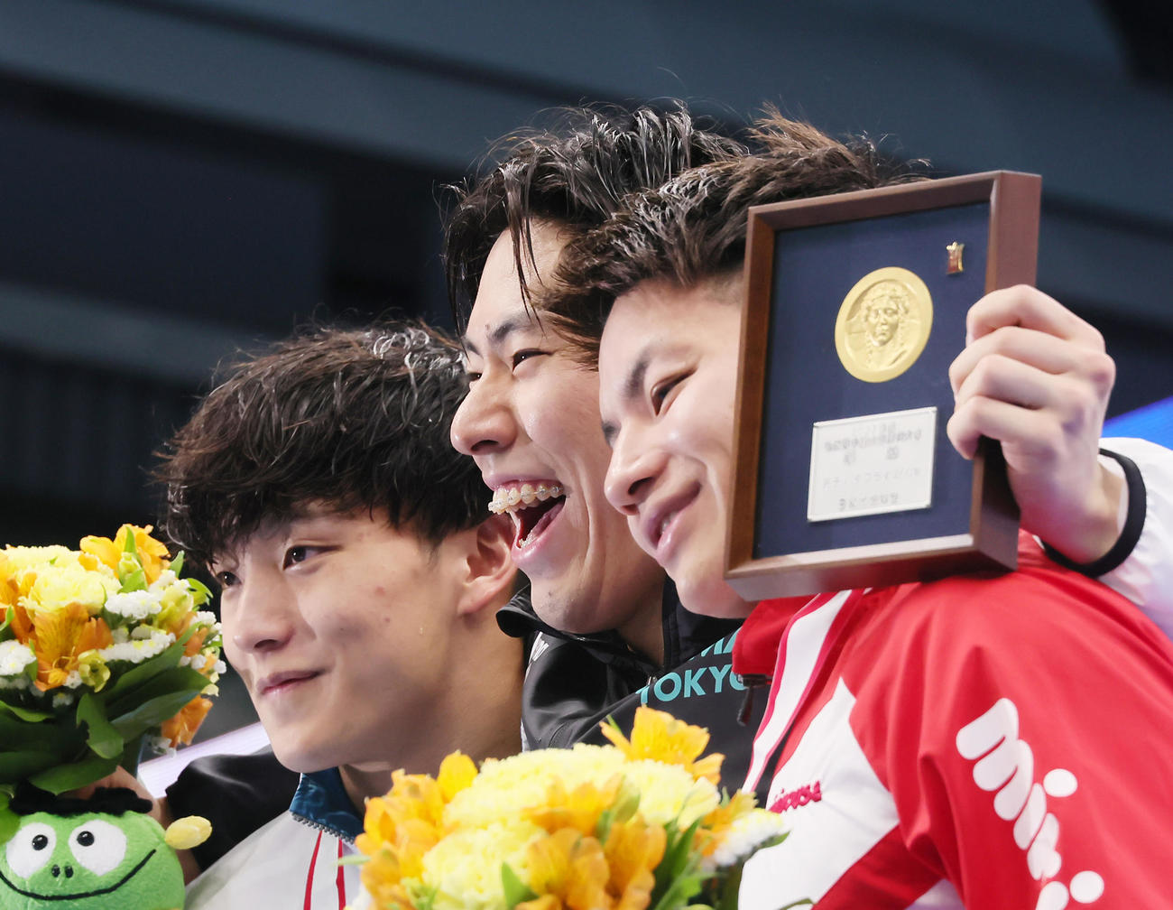 男子200メートルバタフライ決勝の表彰台で笑顔を見せる優勝の本多（中央）。左は2位森本、右は3位寺田（撮影・足立雅史）