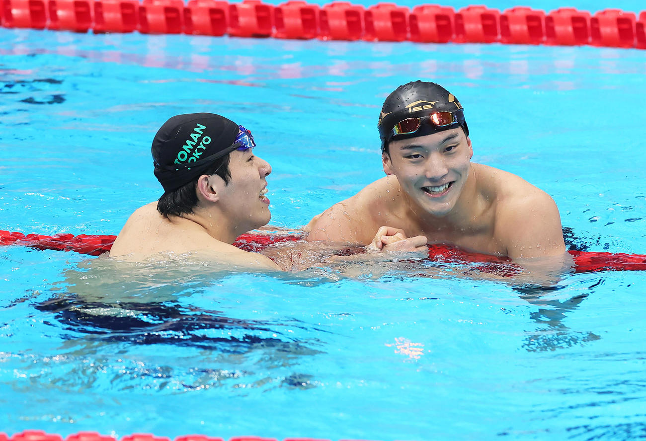 男子200メートルバタフライ決勝を終え、健闘をたたえ合う優勝の本多（左）と2位森本（撮影・足立雅史）