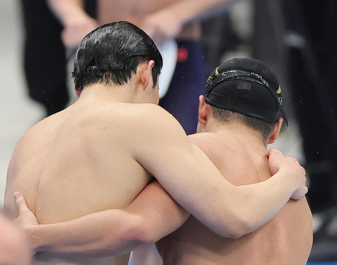 男子200メートルバタフライ決勝を終え、健闘をたたえ合う優勝の本多（左）と2位森本（撮影・足立雅史）