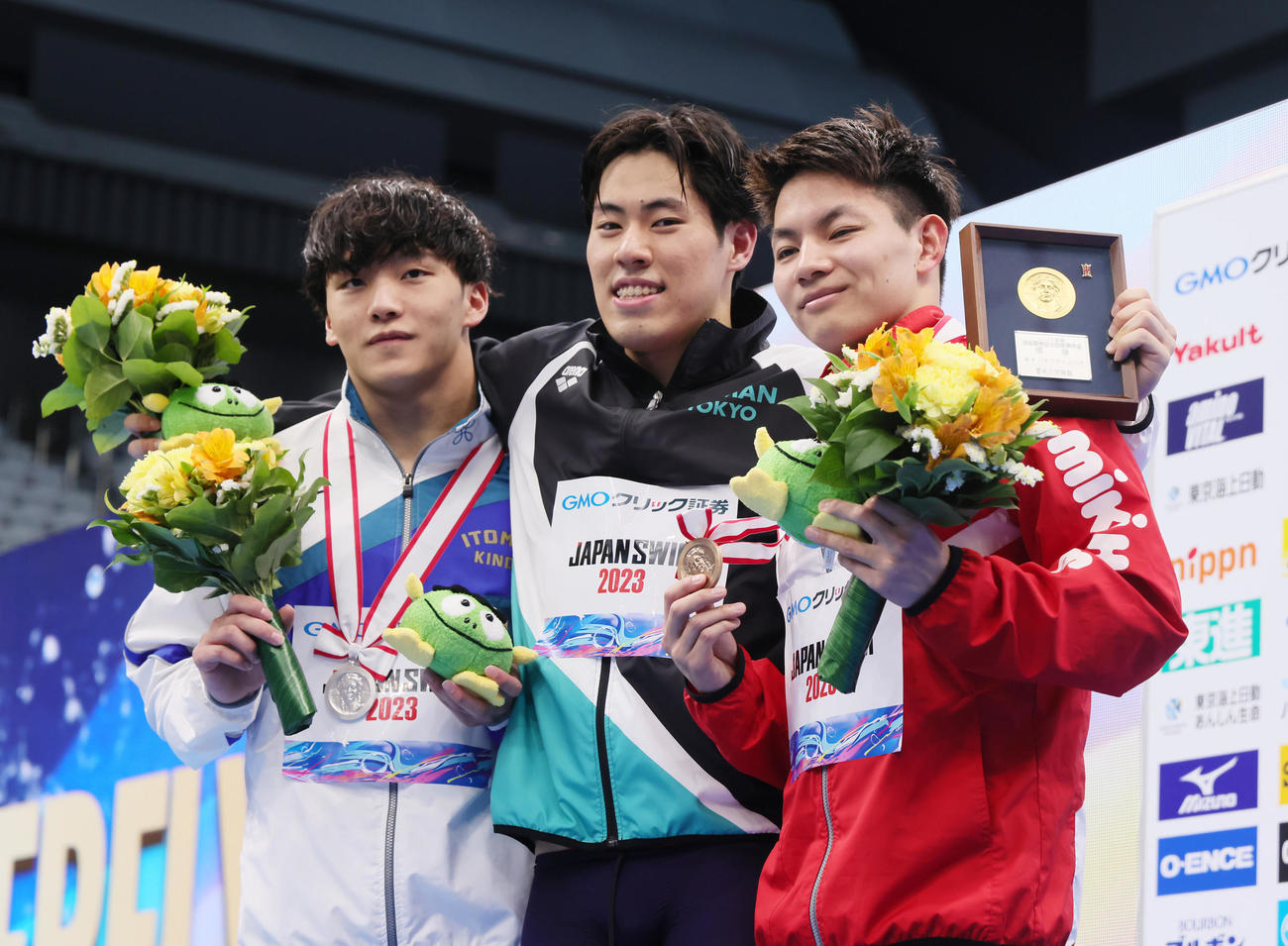 男子200メートルバタフライ決勝の表彰台で笑顔を見せる優勝の本多（中央）。左は2位森本、右は3位寺田（撮影・足立雅史）