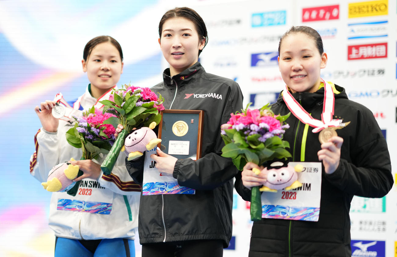 女子100メートル自由形で優勝し笑顔を見せる池江。左は2位の池本、右は3位の白井（撮影・横山健太）