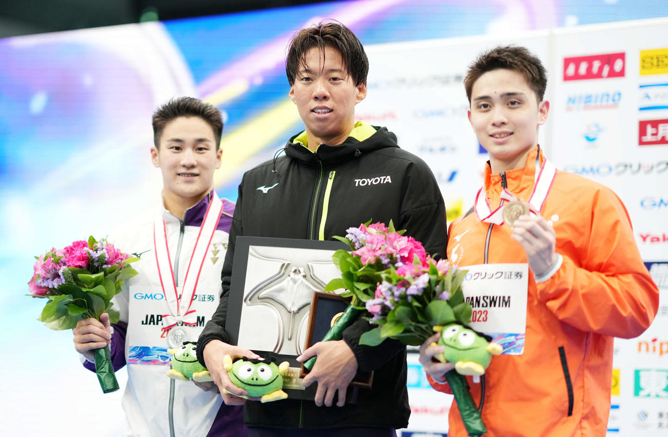 男子200メートル平泳ぎで優勝し笑顔を見せる渡辺。左は2位の佐藤、右は3位の花車（撮影・横山健太）