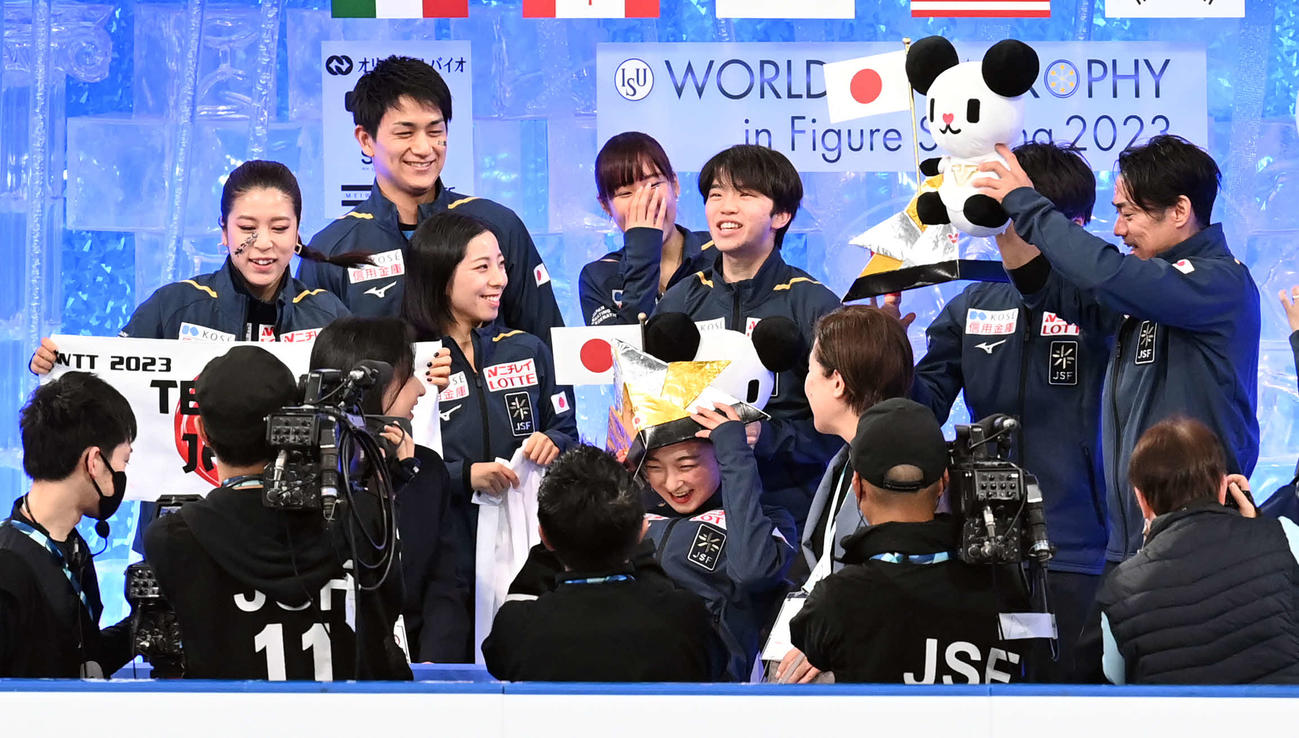 女子SP　採点を待つ間、盛り上げるチームメートに笑顔を見せる坂本（前列中央）（撮影・たえ見朱実）