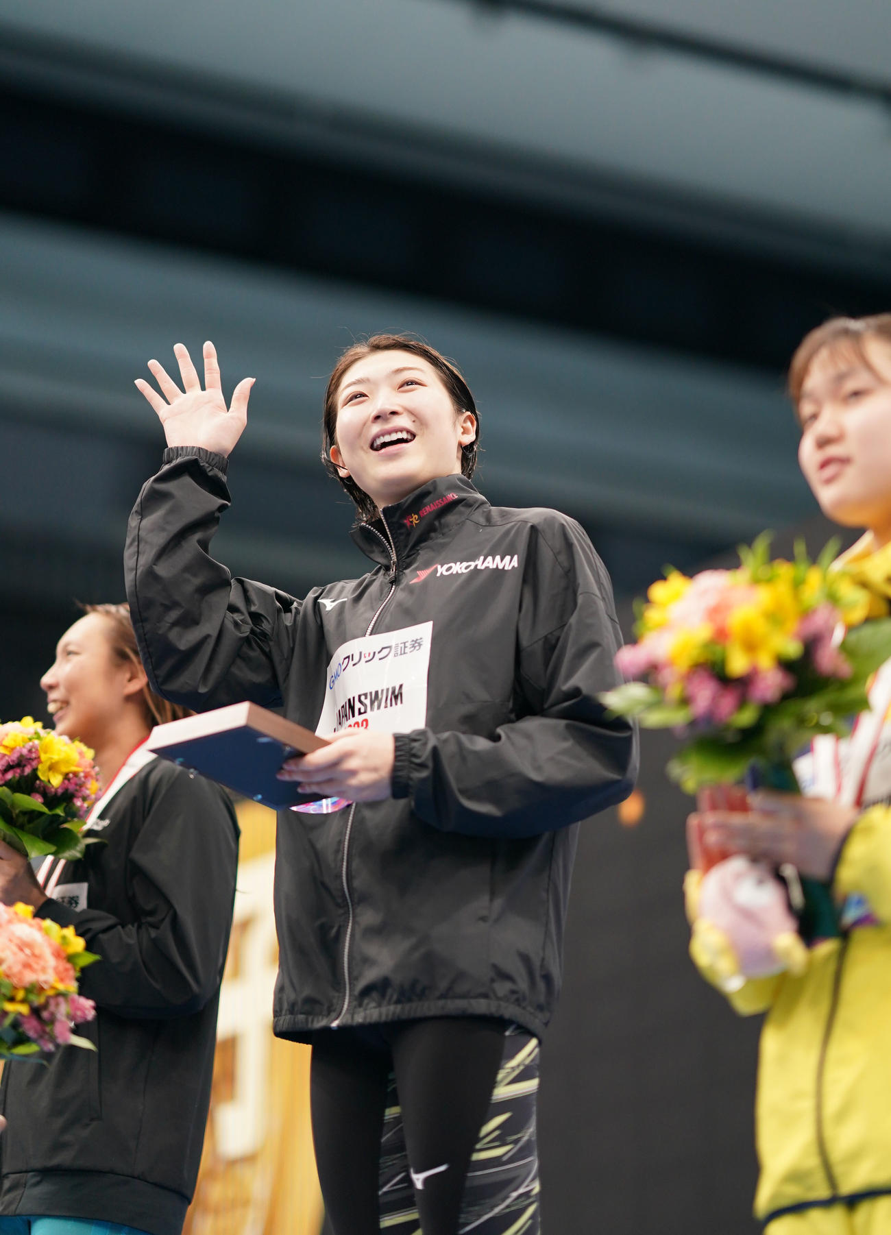 女子50メートルバタフライ決勝で優勝し笑顔で声援に応える池江（中央）（撮影・横山健太）