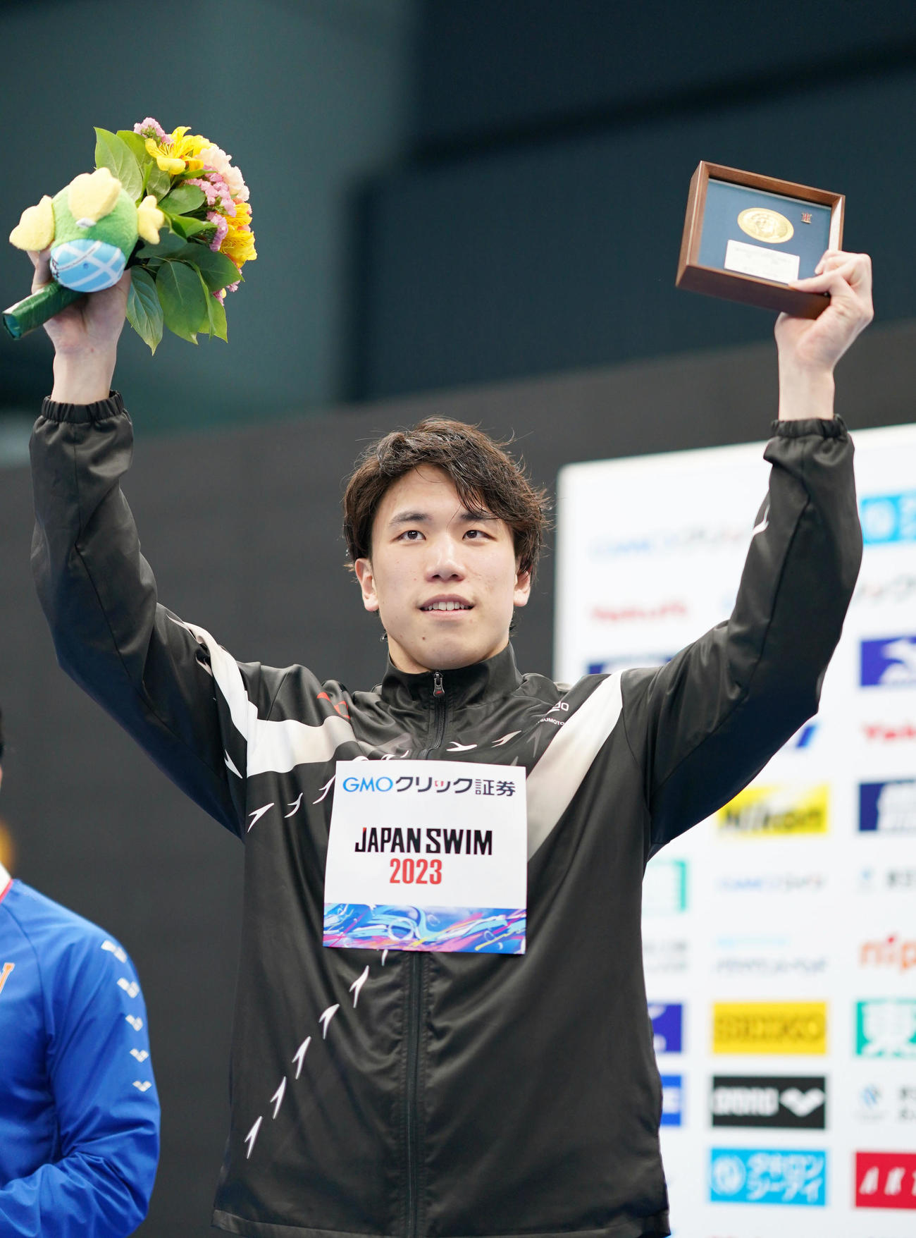 男子100メートルバタフライ決勝優勝し声援に応える松元（撮影・横山健太）