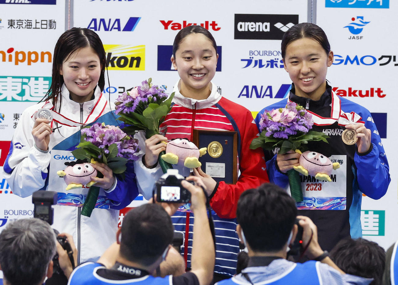 女子400メートル個人メドレーで優勝した成田実生（中央）。左は2位の谷川亜華葉（共同）