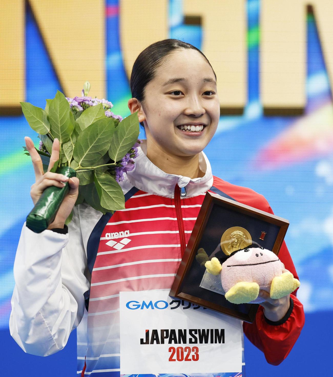 女子400メートル個人メドレーで優勝し、笑顔でポーズをとる成田実生（共同）