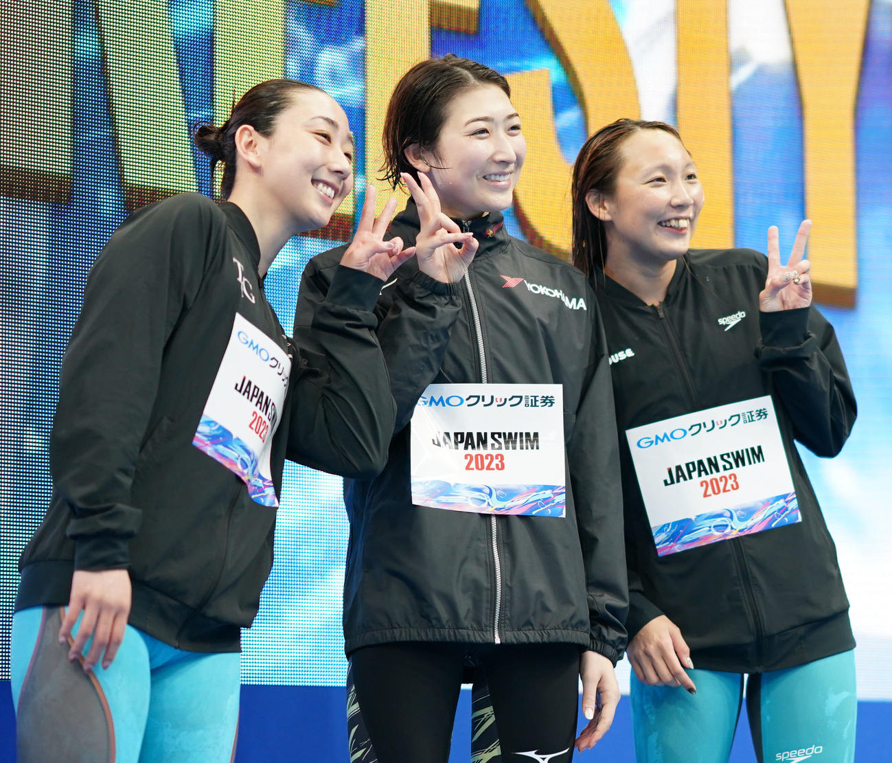 女子50メートル自由形で優勝し笑顔を見せる池江。左は2位の五十嵐、右は3位の相馬（撮影・横山健太）
