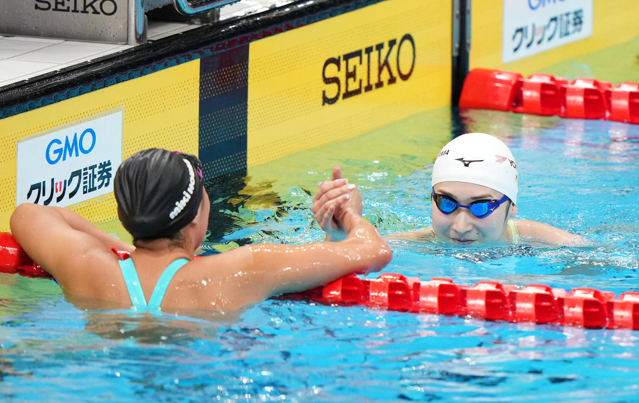 女子50メートル自由形決勝で優勝し相馬（左）と握手を交わす池江（撮影・横山健太）