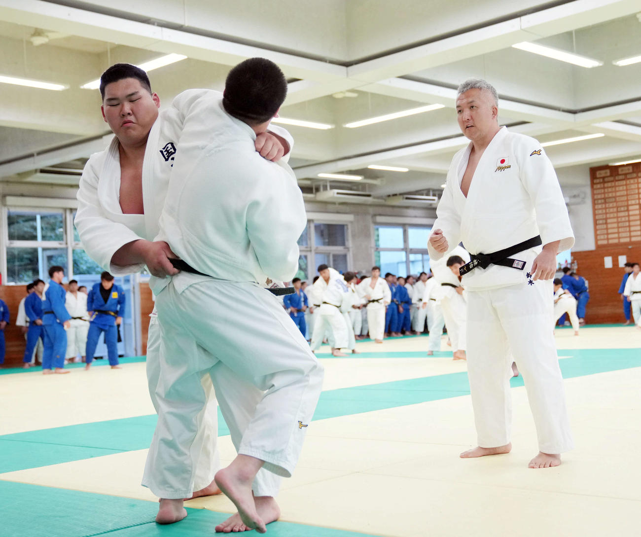 柔道男子日本代表の世界選手権に向けた合宿で、鈴木監督（右）が見守る中、組み手練習をする斉藤
