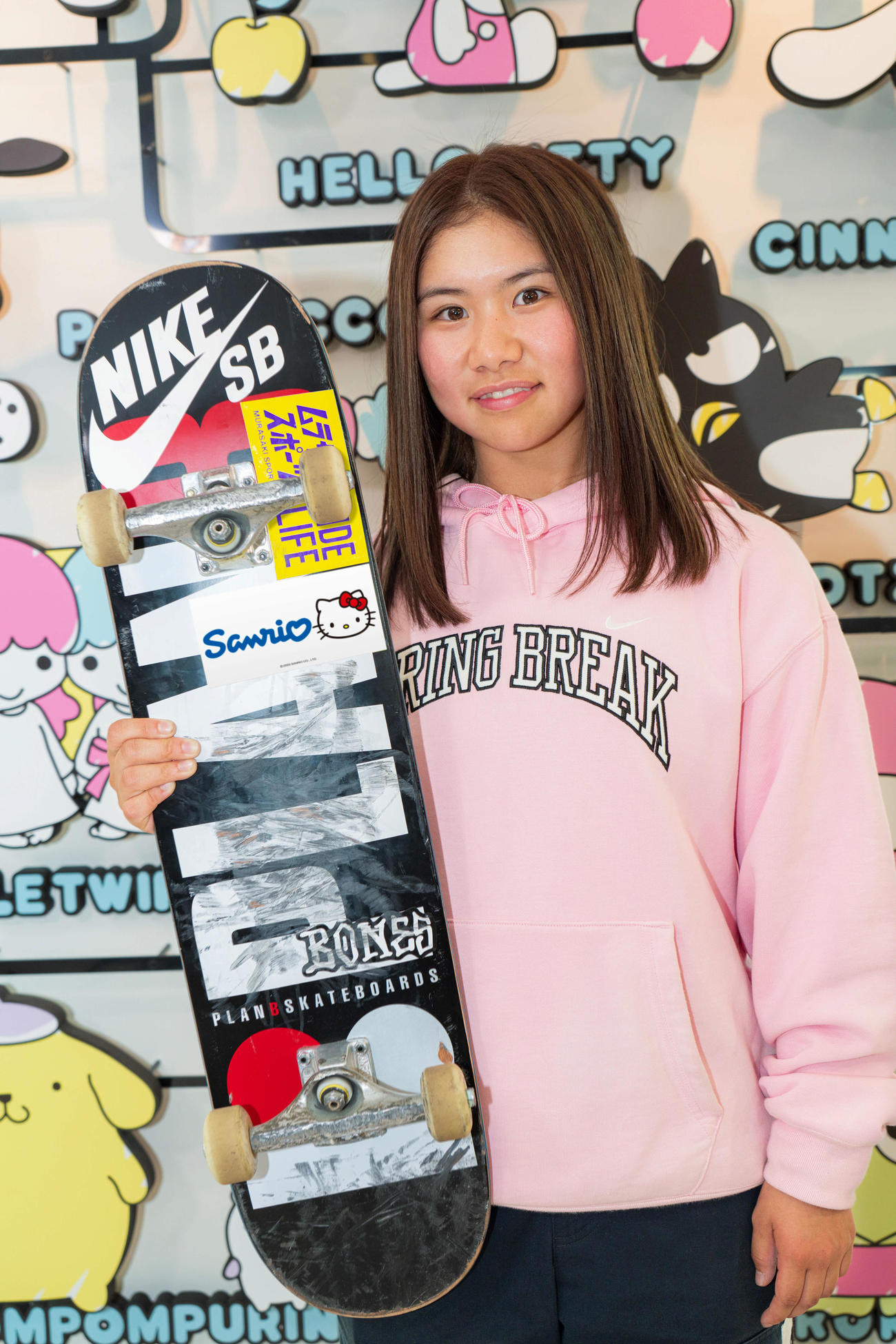 サンリオと所属契約を結び、ハローキティと同社ロゴステッカーつきのデッキを手にする織田（株式会社サンリオ提供）