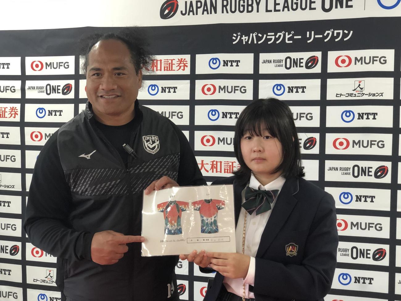 元日本代表で花園普及担当のタウファ統悦さん（左）と記念撮影する「未来ジャージーコンテスト」でグランプリに選ばれた前田彩吹さん