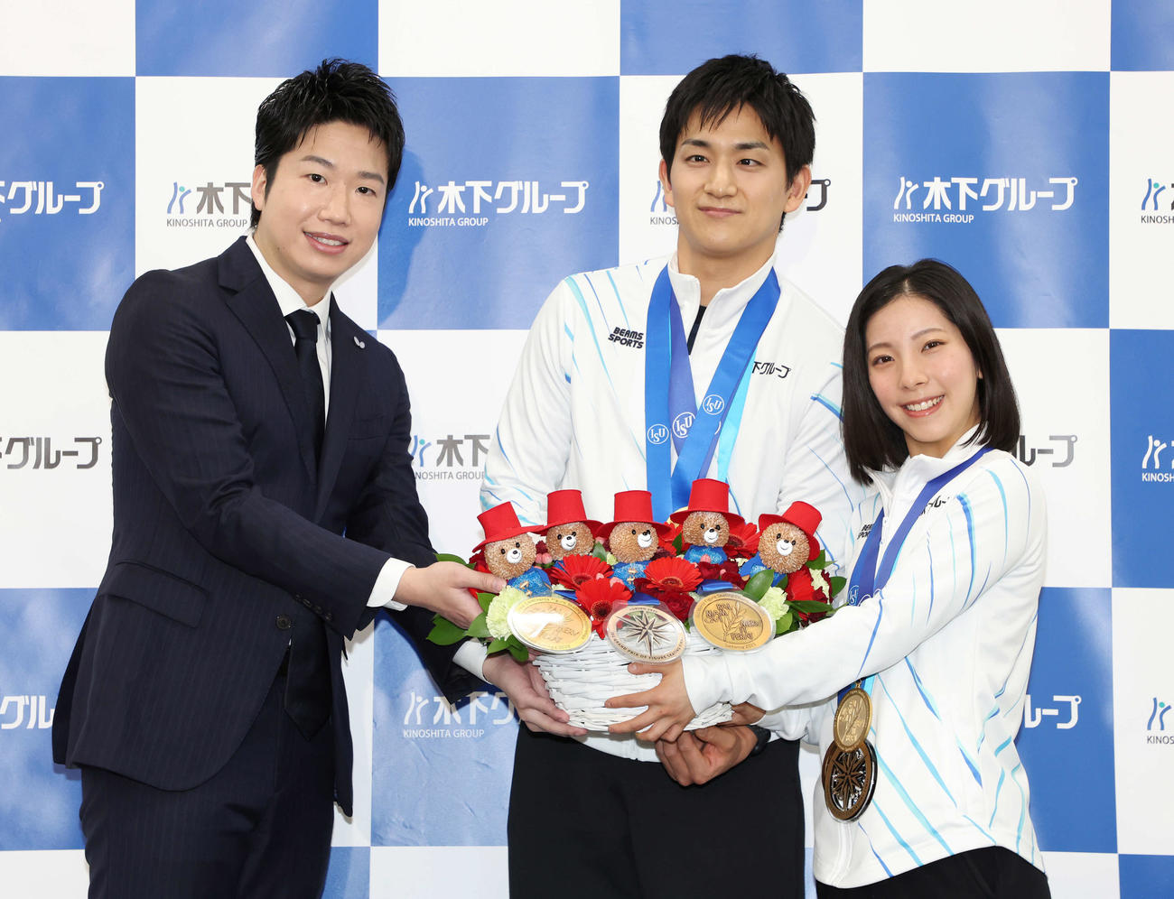年間グランドスラム達成報告会で水谷隼氏（左）から花束を受け取る木原（中央）と三浦組（撮影・宮地輝）