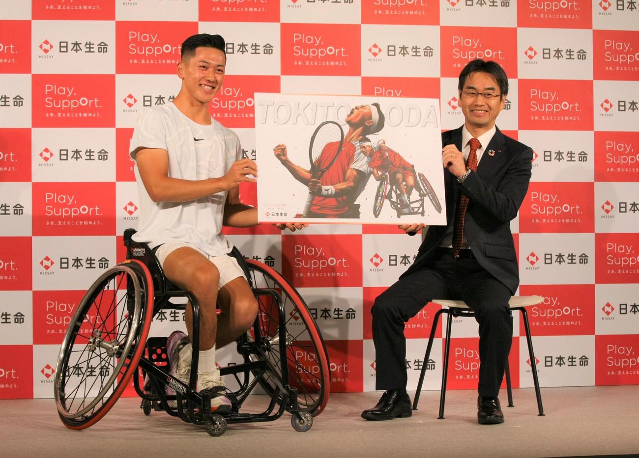 日本生命スポンサー契約発表記者会見で、イラストアーティスト田村大さんが描いた絵をプレゼントされ、笑顔を見せる車いすテニスプレーヤーの小田（左）と日本生命の高田保豊常務執行役員（撮影・藤塚大輔）