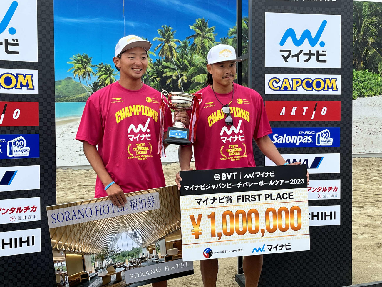 優勝トロフィーを掲げる倉坂（左）と長谷川徳