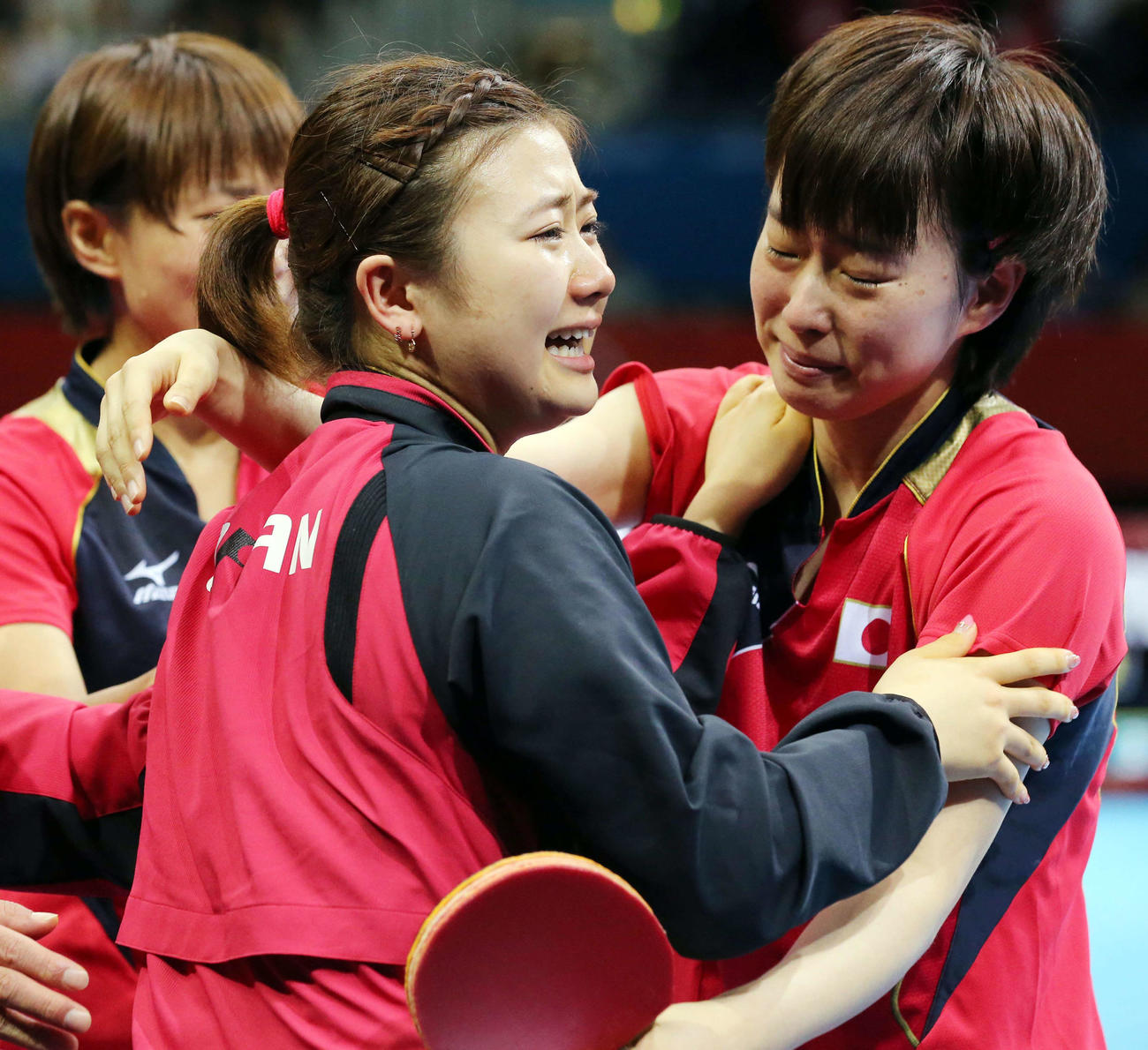 12年8月、ロンドン五輪・卓球女子団体準決勝でシンガポールにストレート勝ちし、日本の福原愛（左）と石川佳純は涙を流しながら抱き合う。後方は平野早矢香（2012年8月5日撮影）