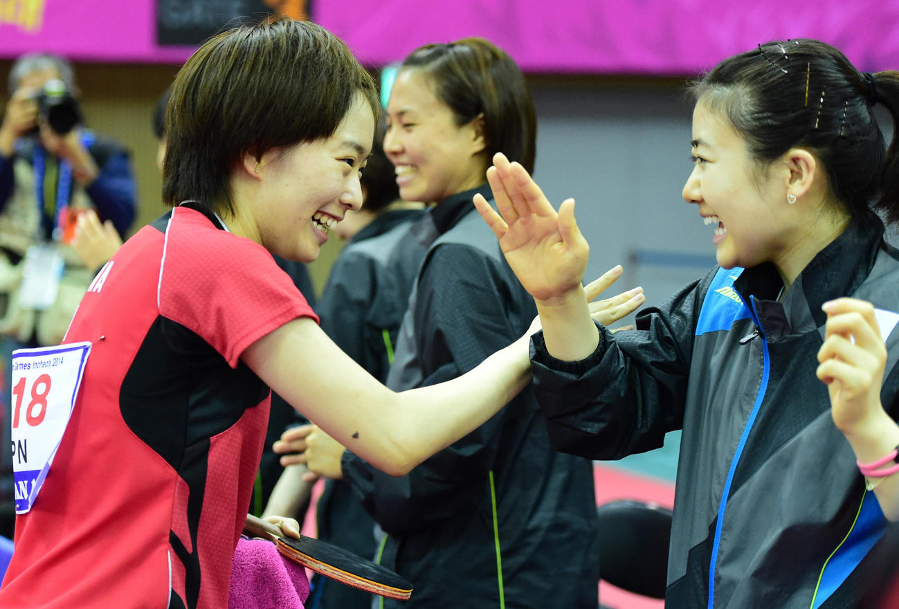 女子団体で決勝進出を決めタッチを交わす石川（左）と福原（右）。中央は平野（2014年9月29日撮影）