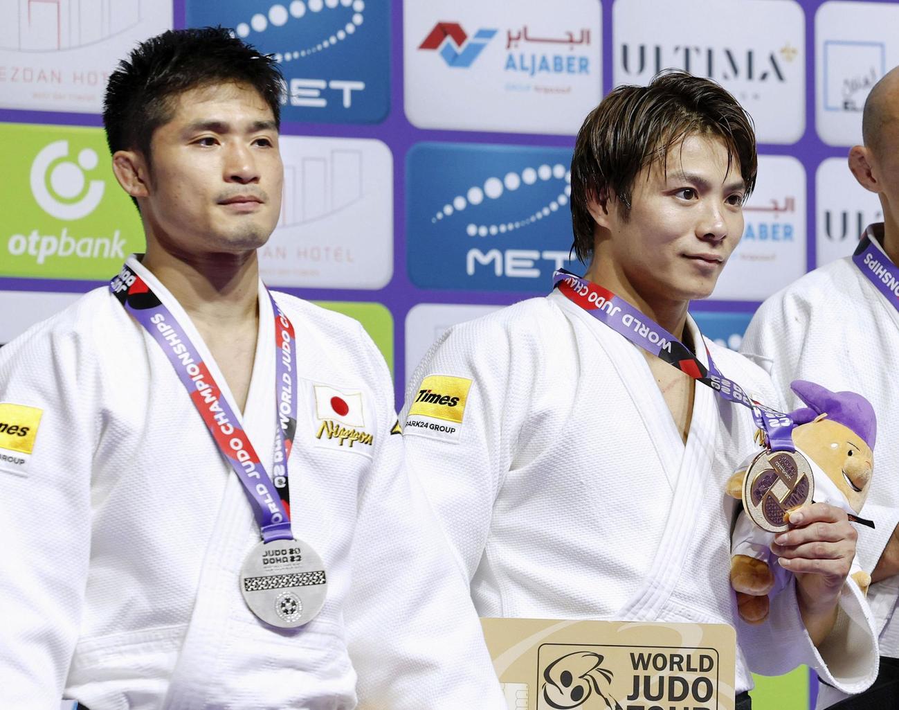 金メダルを手にする阿部一二三。左は銀メダルの丸山城志郎（共同）