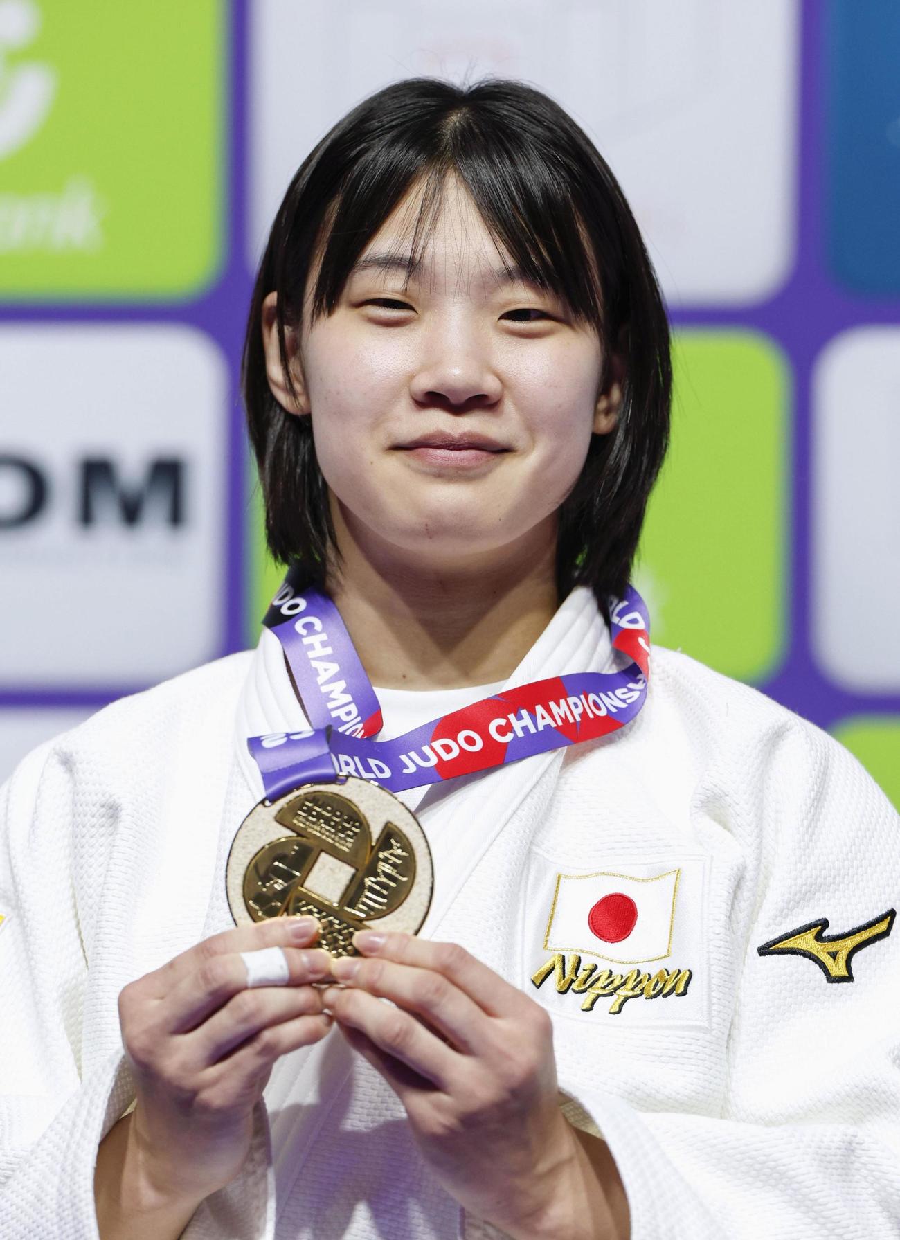 女子70キロ級で初優勝を果たし、金メダルを手に笑顔の新添左季（共同）