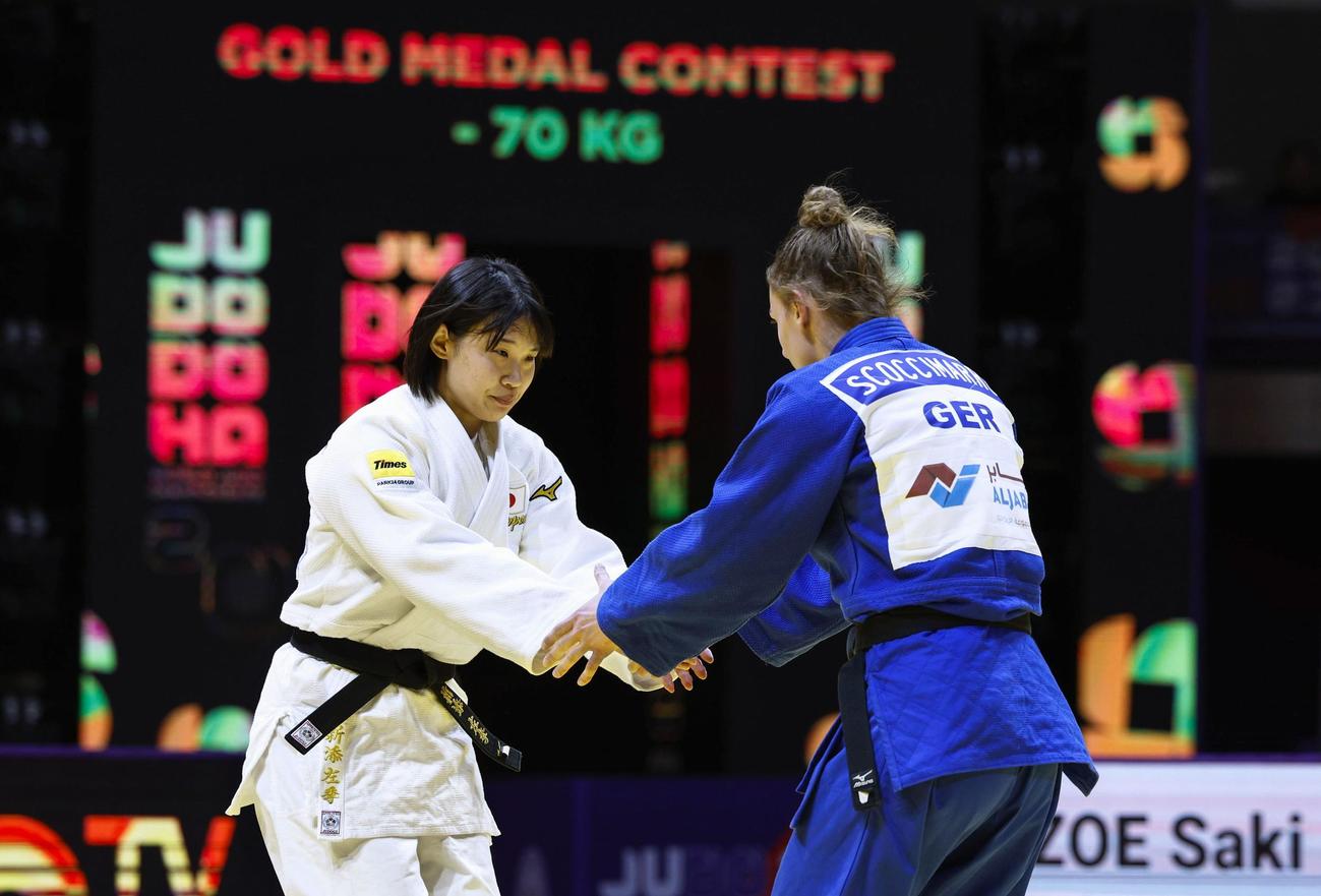 女子70キロ級でドイツ選手（右）を破って初優勝し、健闘をたたえ合う新添左季（共同）